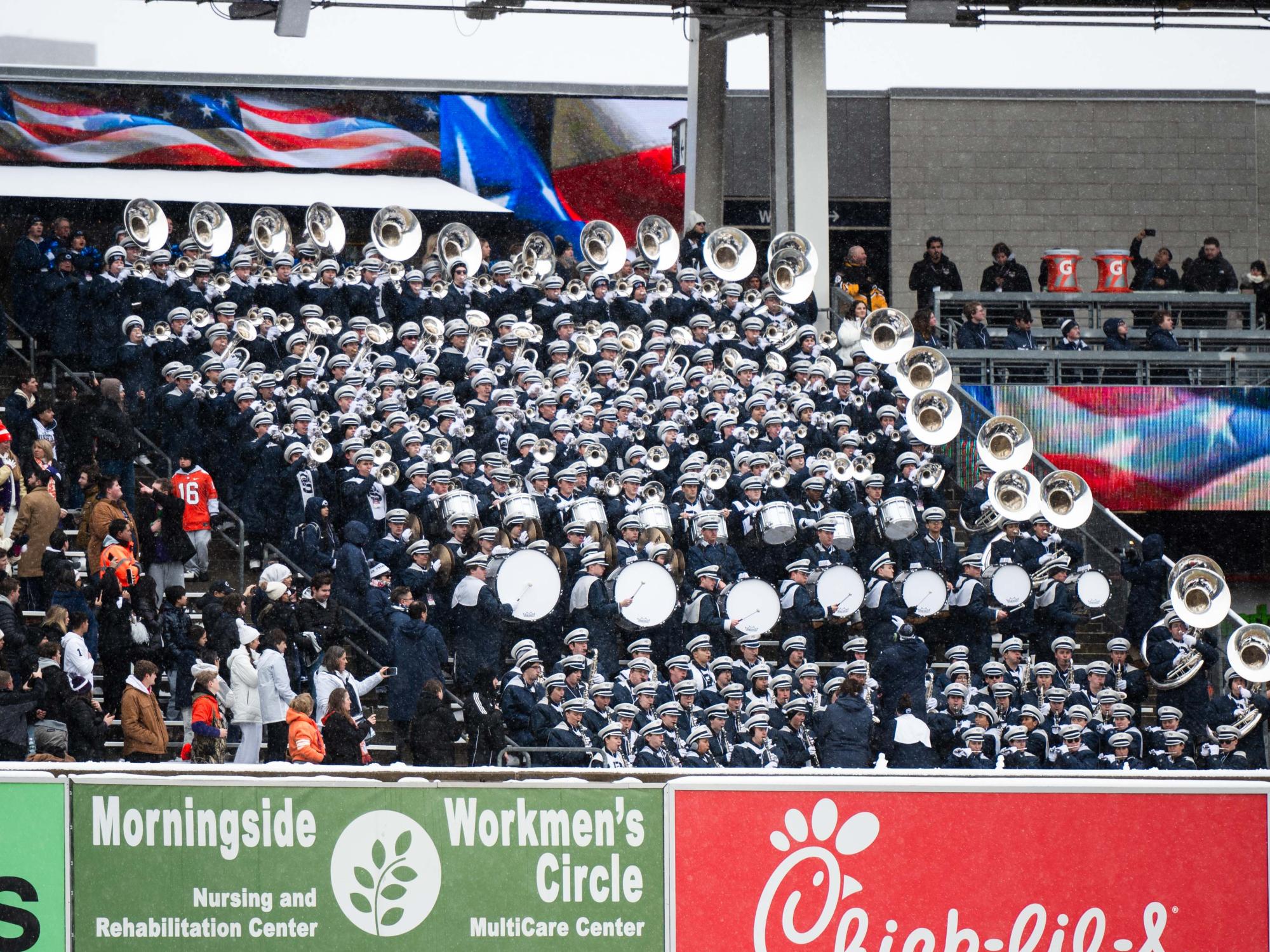 A band sits in the stands and play their instrument
