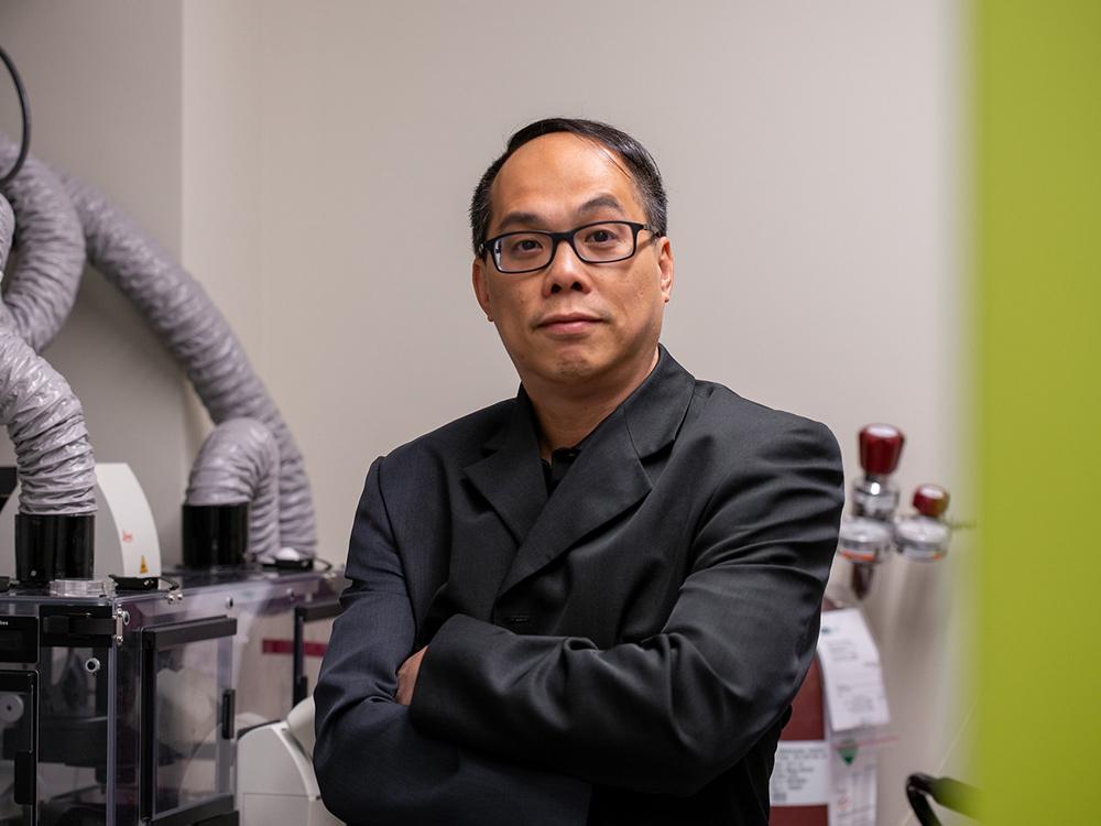 Pak Kin Wong, professor of biomedical engineering and of mechanical engineering at Penn State, standing in a lab looking at the camera
