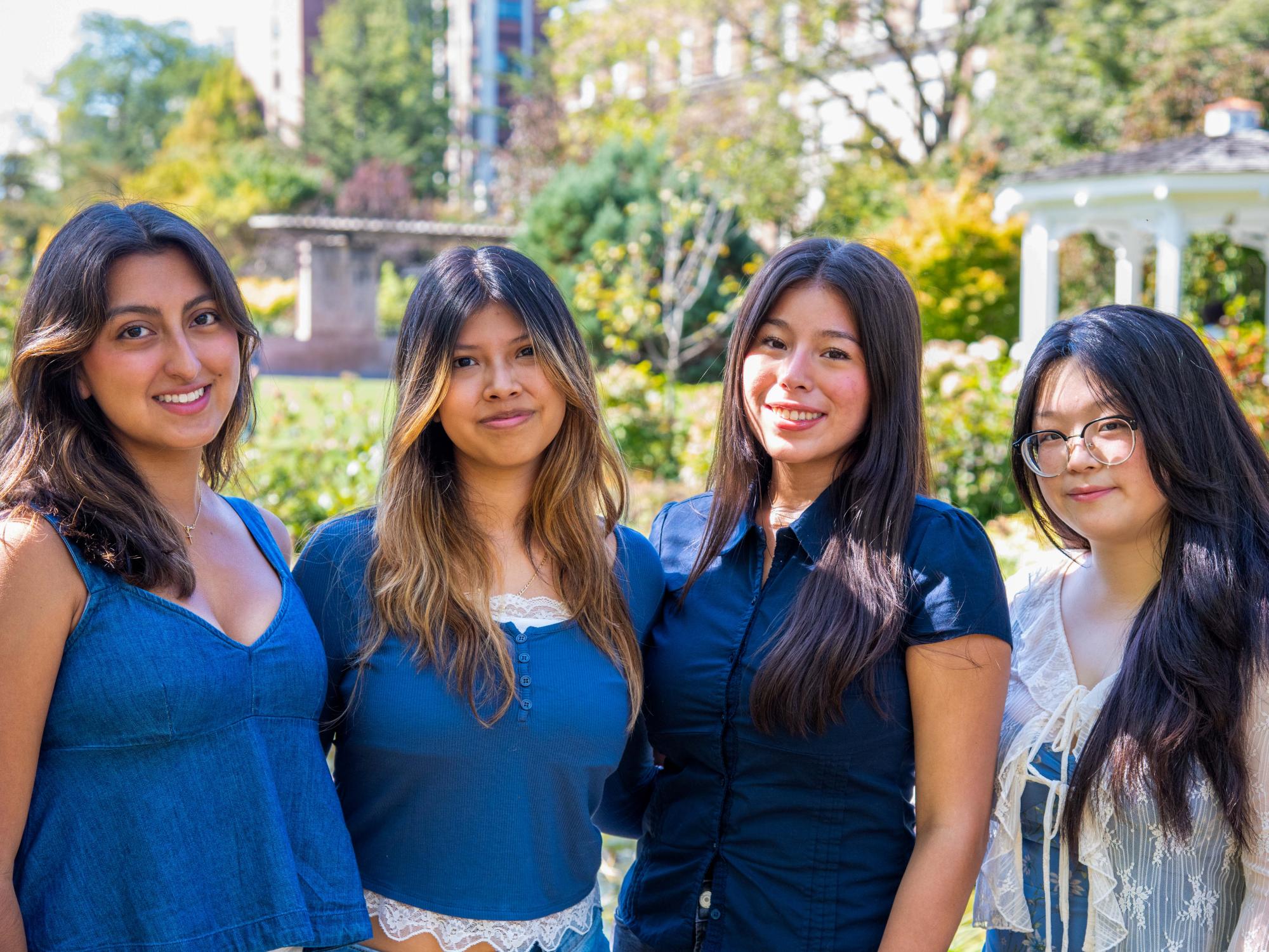 Delany Moreno (left) stands with three other students outside the Hintz Family Alumni Center.