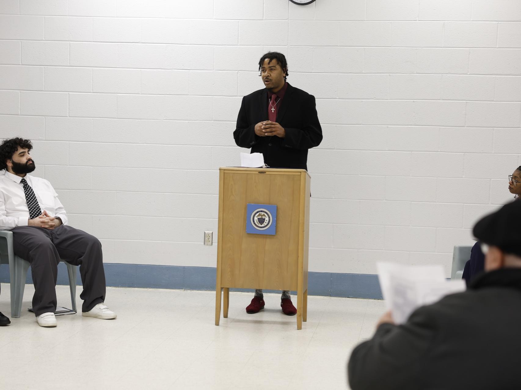 Ashma Smith speaking behind a podium in the George W. Hill Chapel