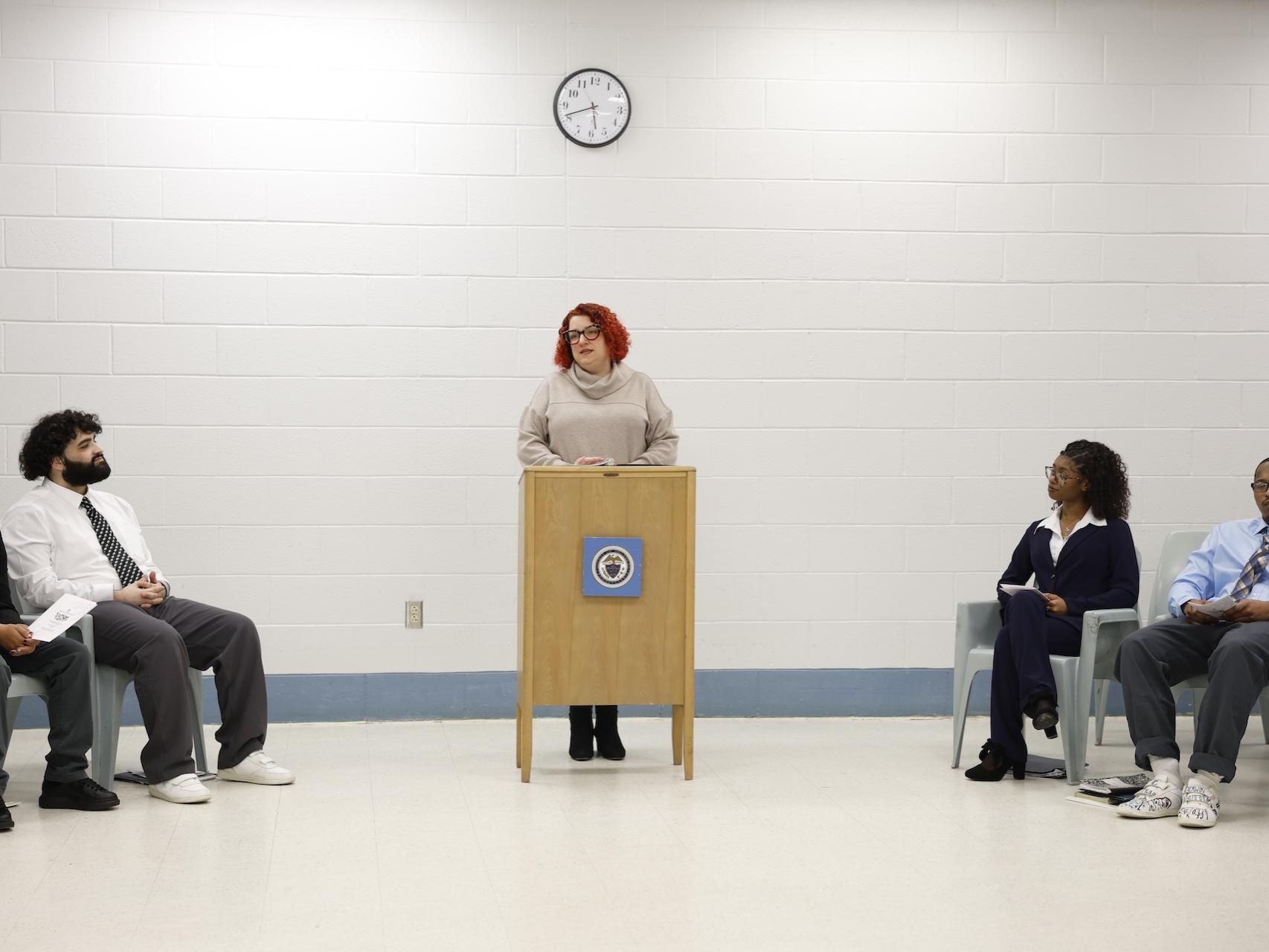 Angela Putman speaking behind a podium in the George W. Hill chapel. 