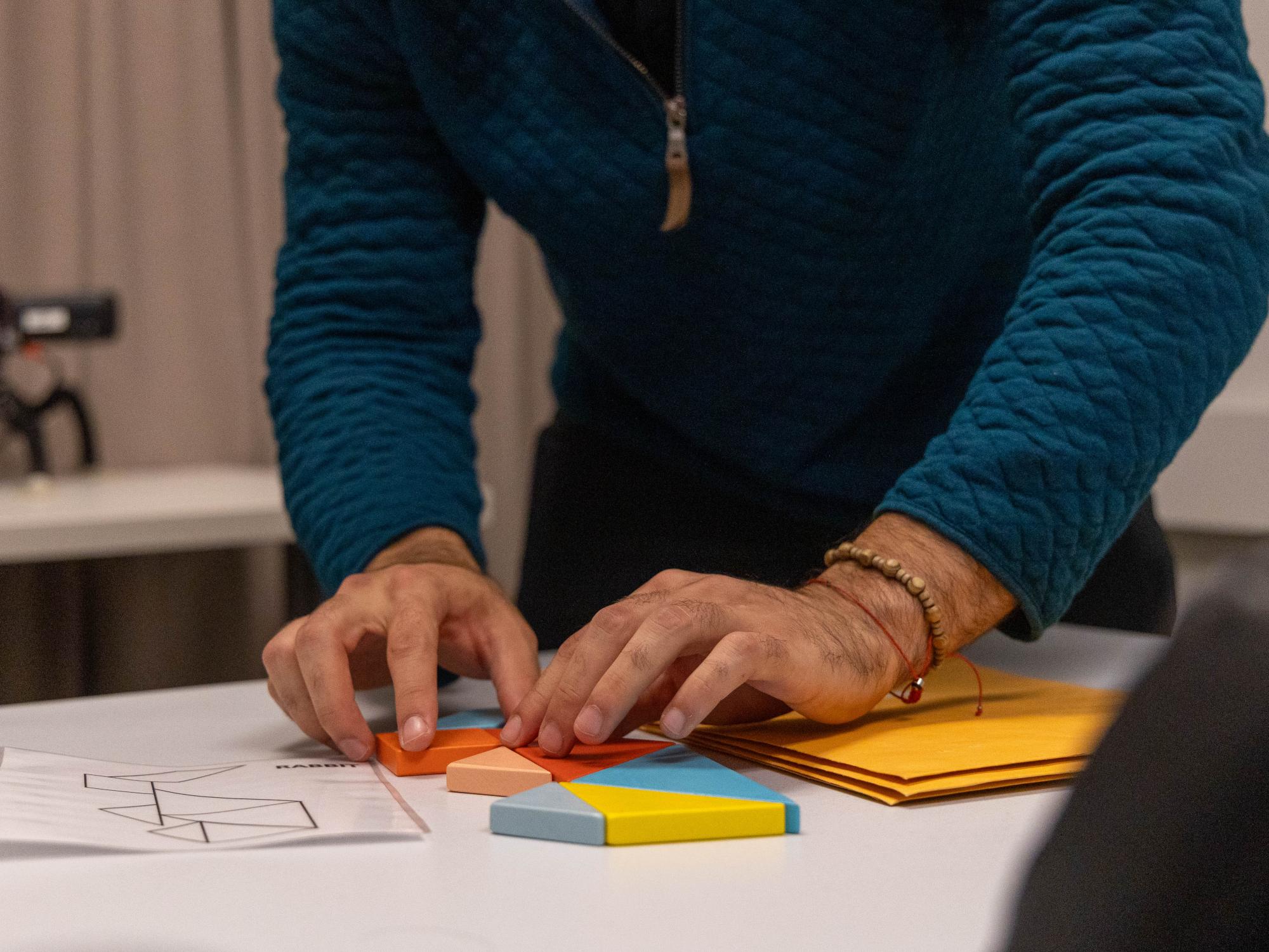 Penn State student Miguel Morazan demonstrates how to assemble a tangram puzzle that participants will complete during one of the tasks in the College of the Liberal Arts' CAT Lab.