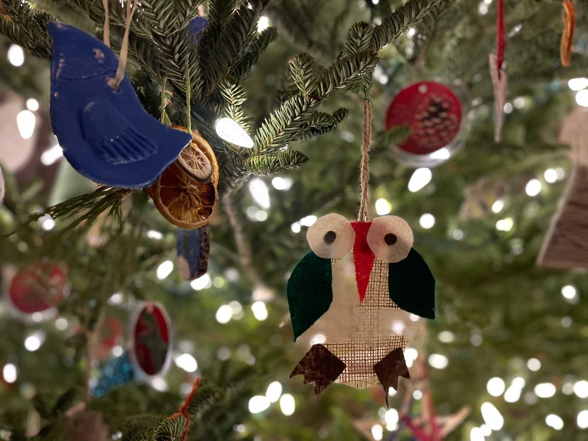 Several crafty handmade ornaments on tree branches in a close-up image