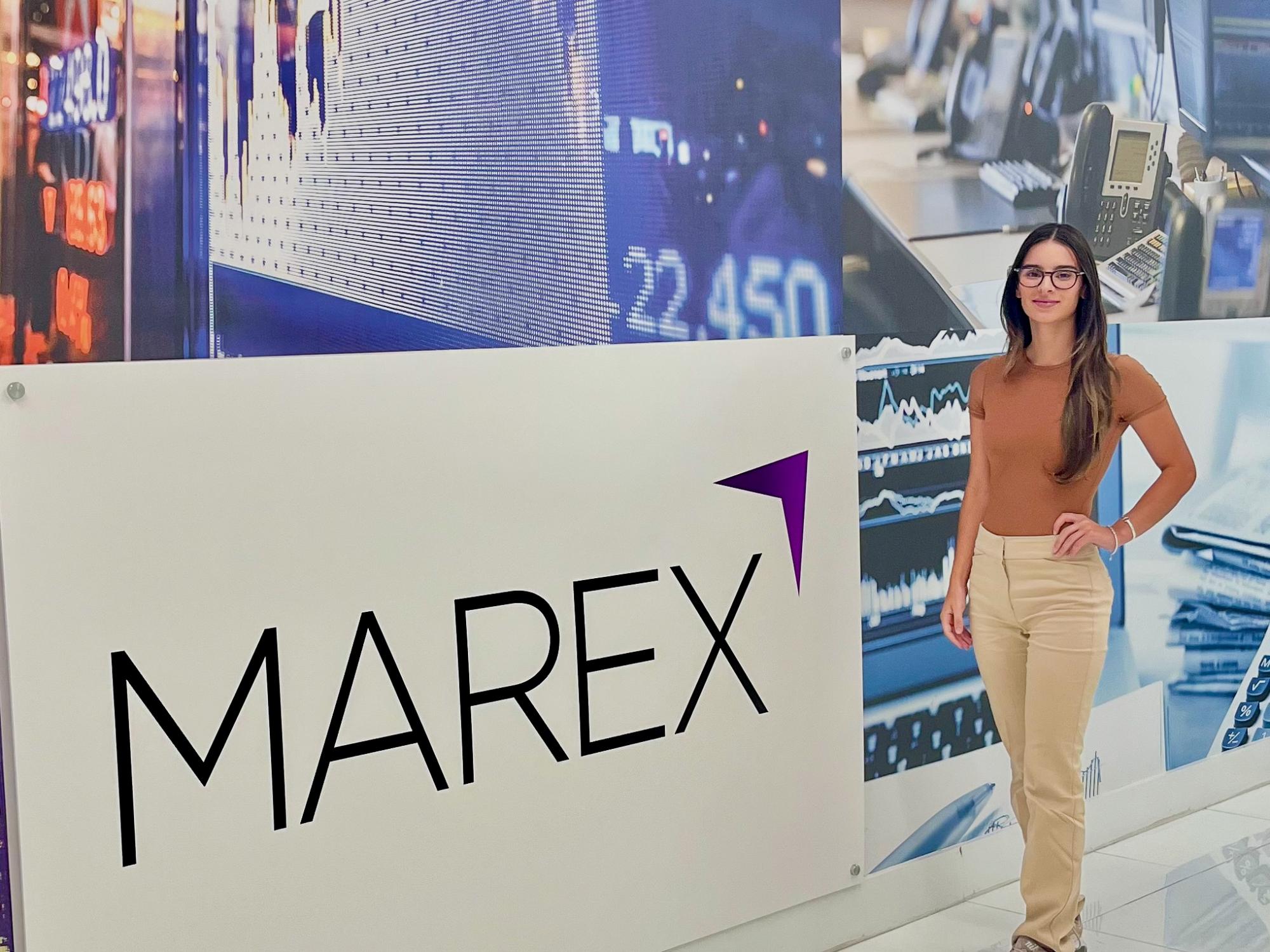 Kayla Lynch strikes a pose in front of Marex’s sign.