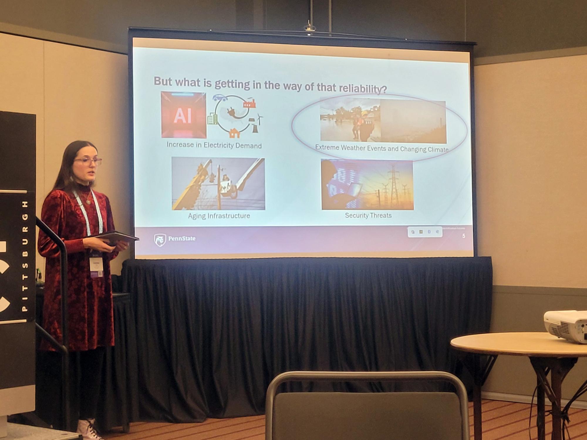 Courtney Cole stands at a podium presenting a slide on factors affecting electric grid reliability, including extreme weather and increased electricity demand, during a conference session.