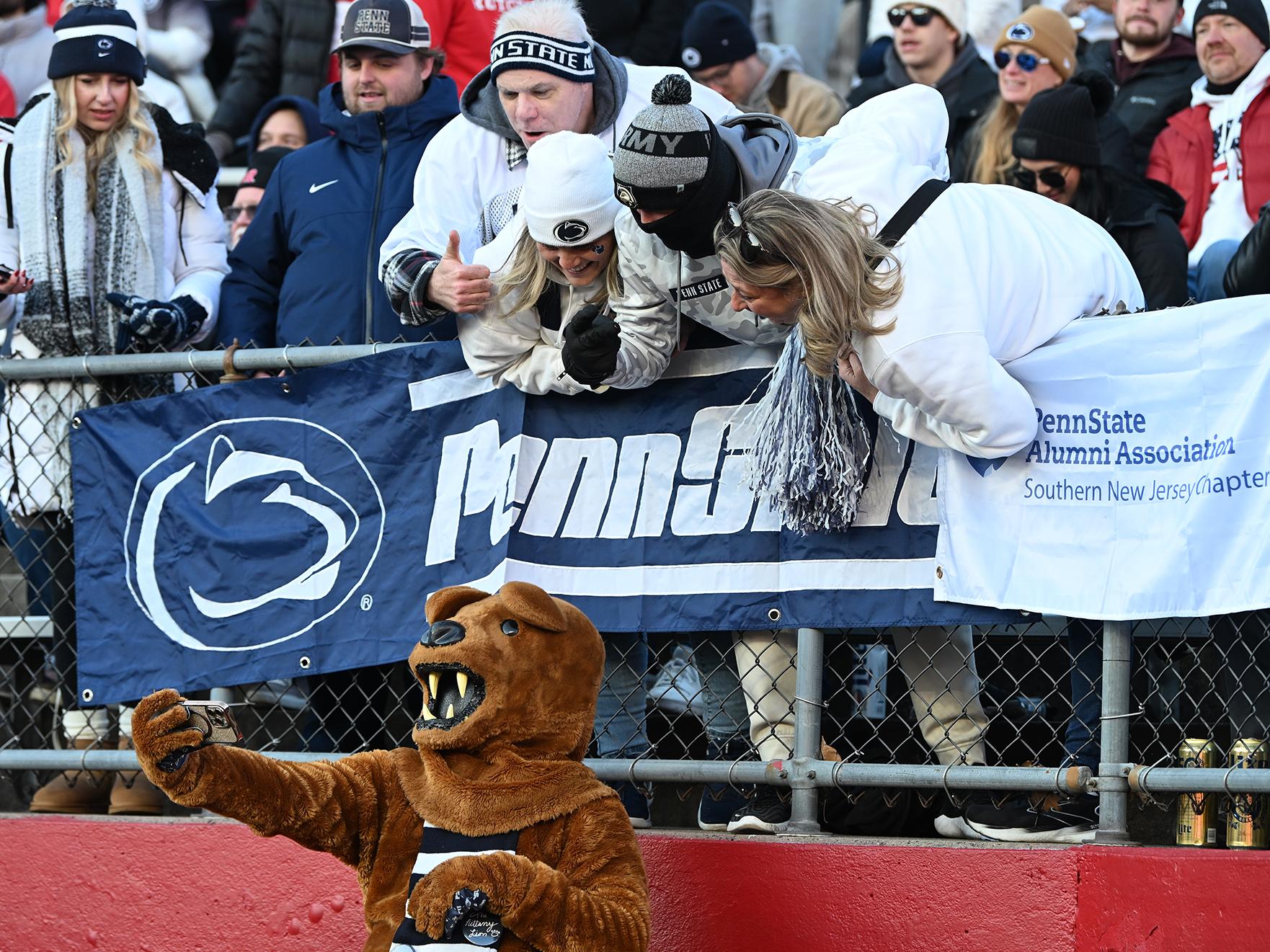 Mascot takes selfie with fans in stands