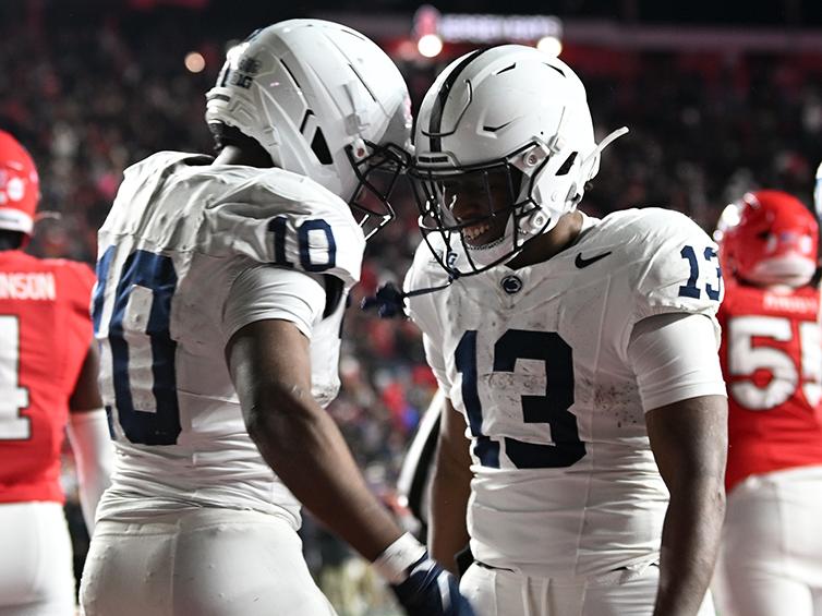 Two players bump helmets in celebration