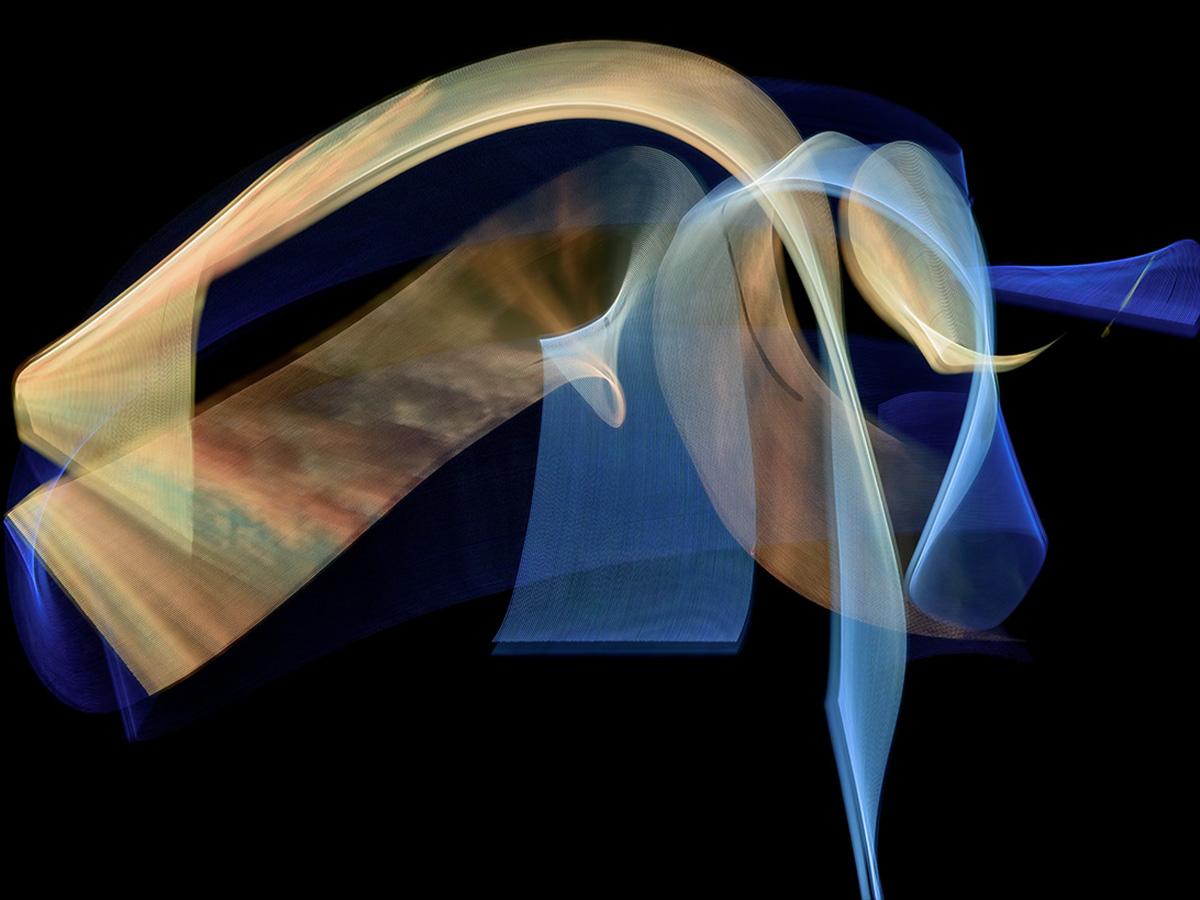 A sweeping abstract light form in gold, blue and soft brown tones, layered in ribbon-like curves against a black background.