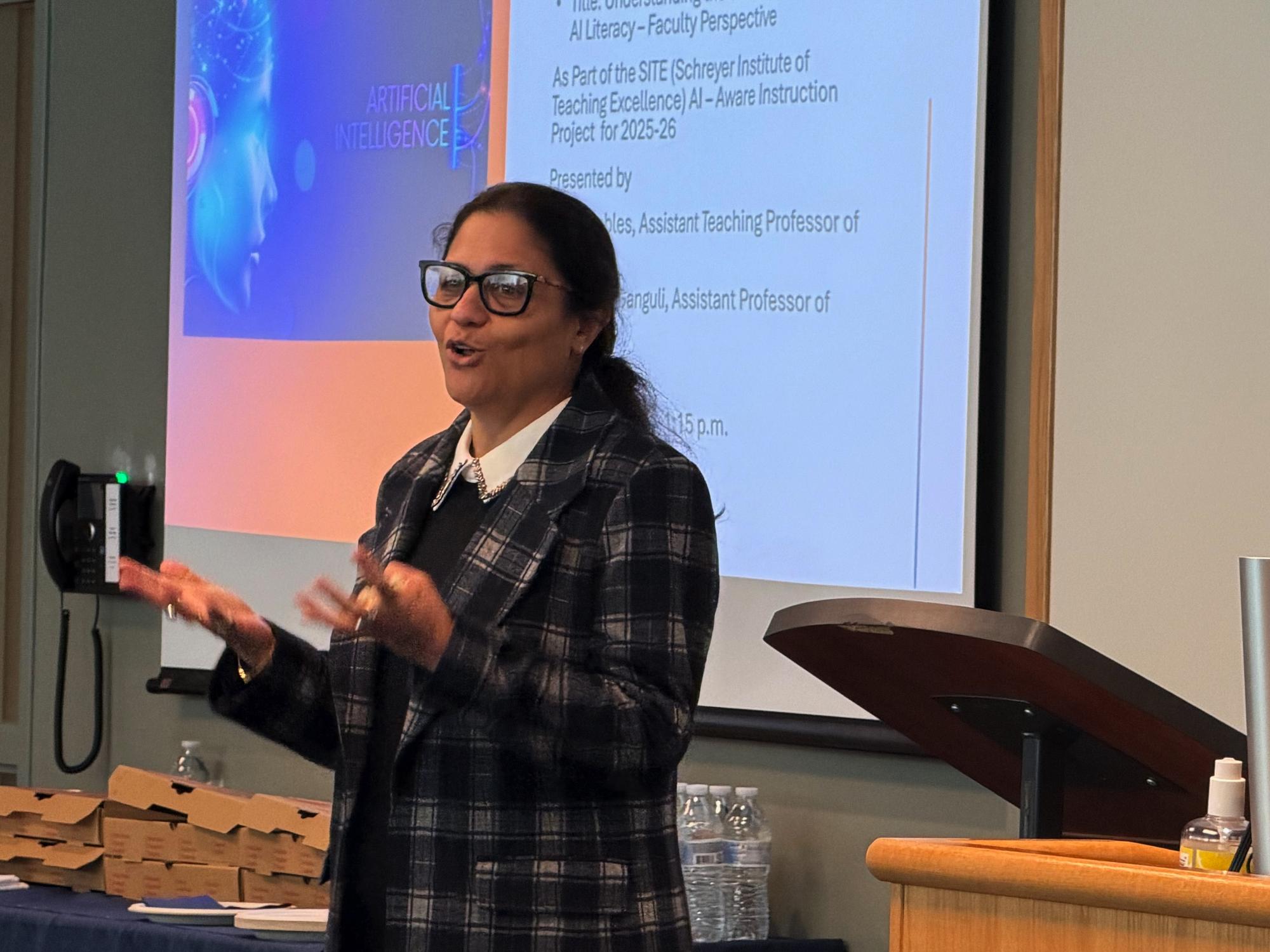 Su Ganguli presented in front of a screen with her hands gesturing forward