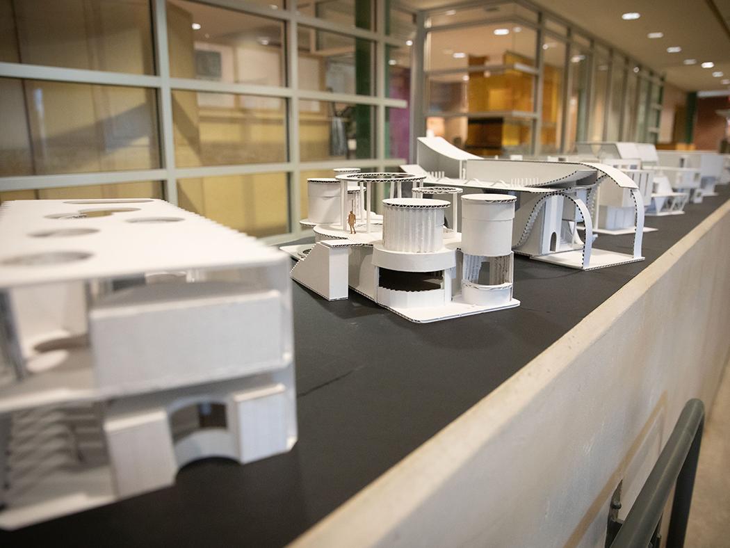 White architectural models lined up on a black surface. 