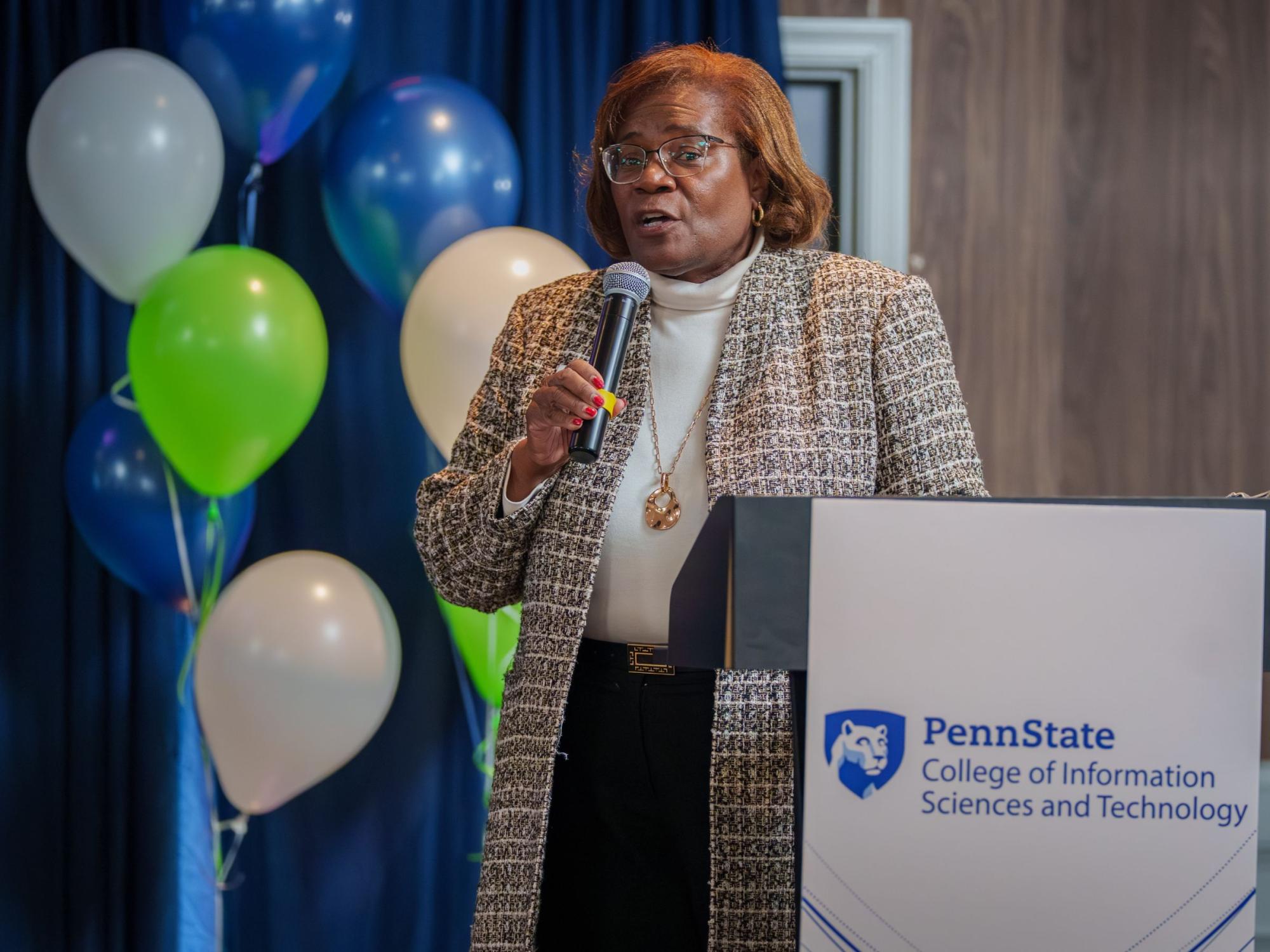 person holding microphone standing next to podium