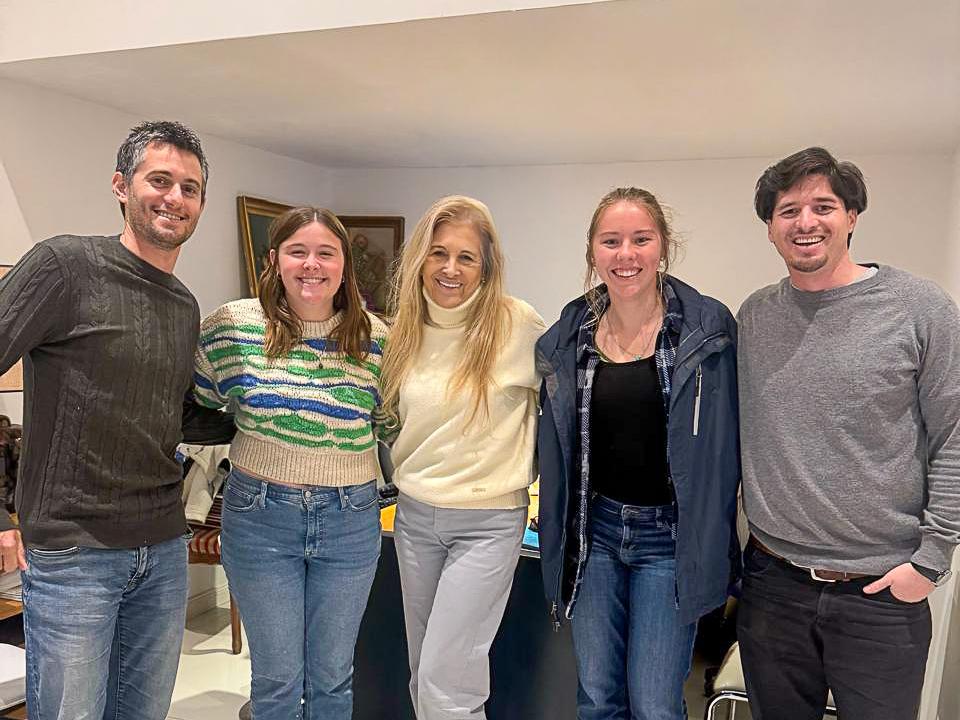 Shelby Corbett wears jeans and a jacket while posing with four others.