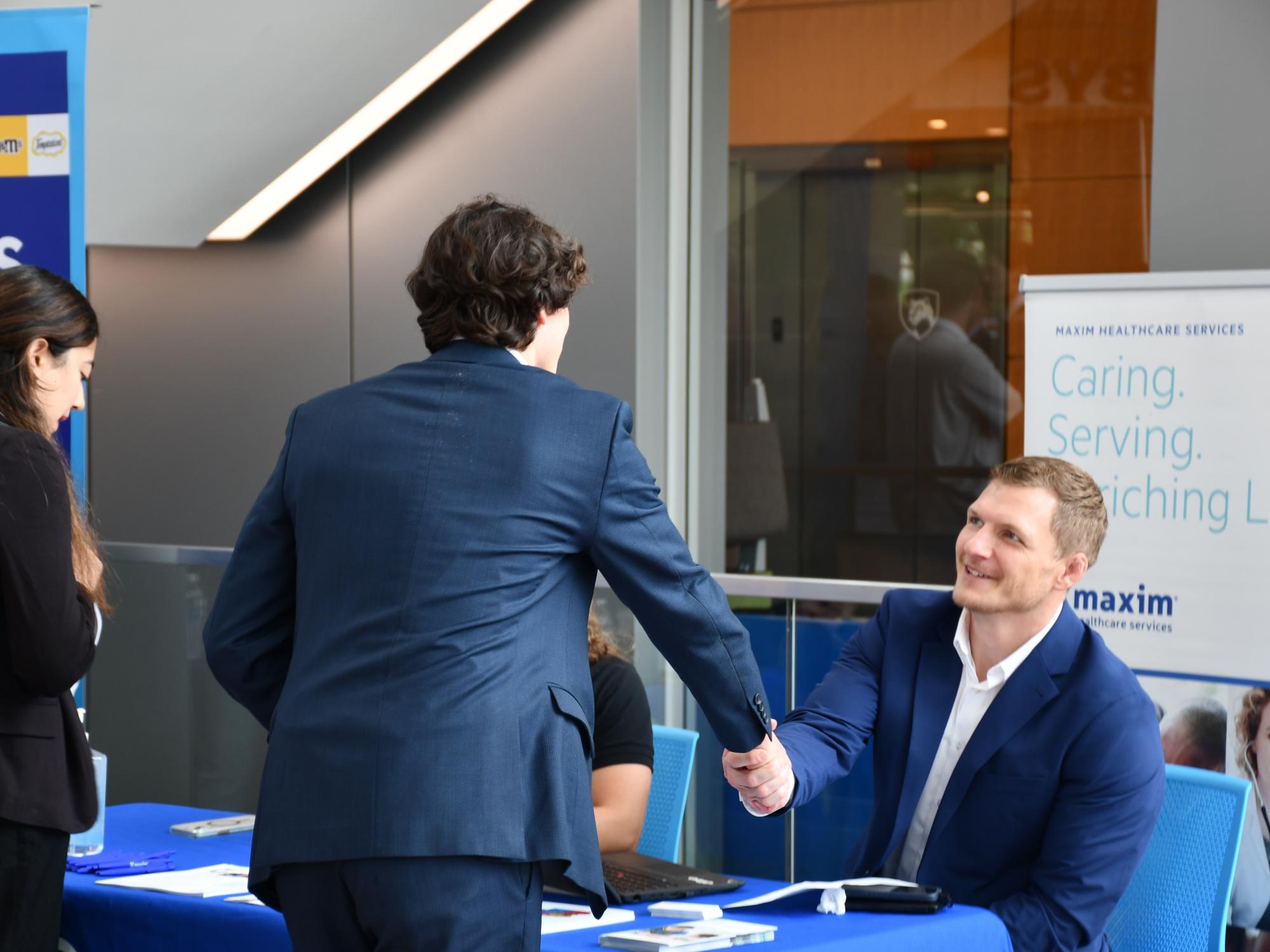 Student shaking hands with a corporate recruiter at the Smeal Business Career Fair