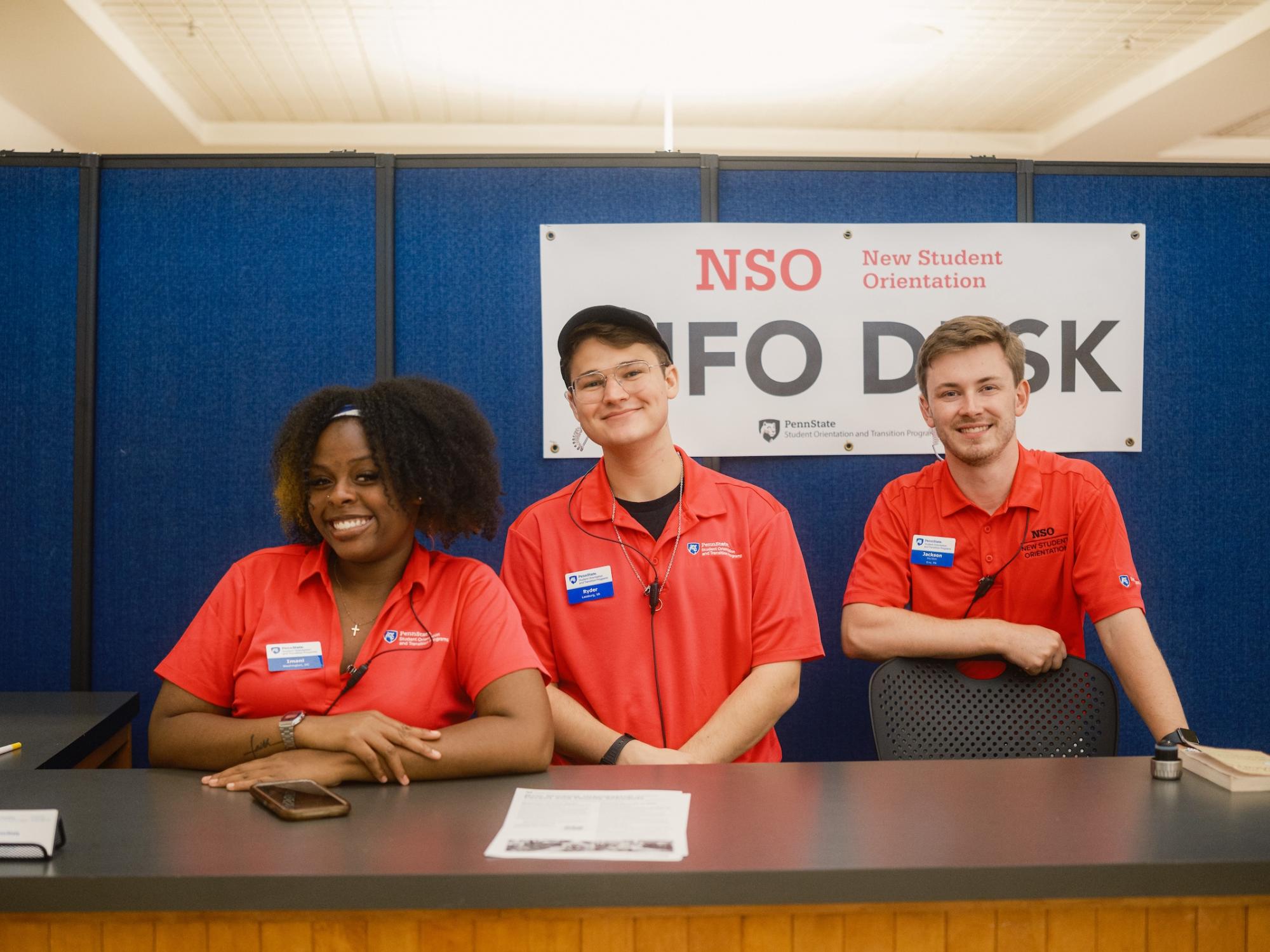 Three orientation leaders pose for photo at the NSO info desk