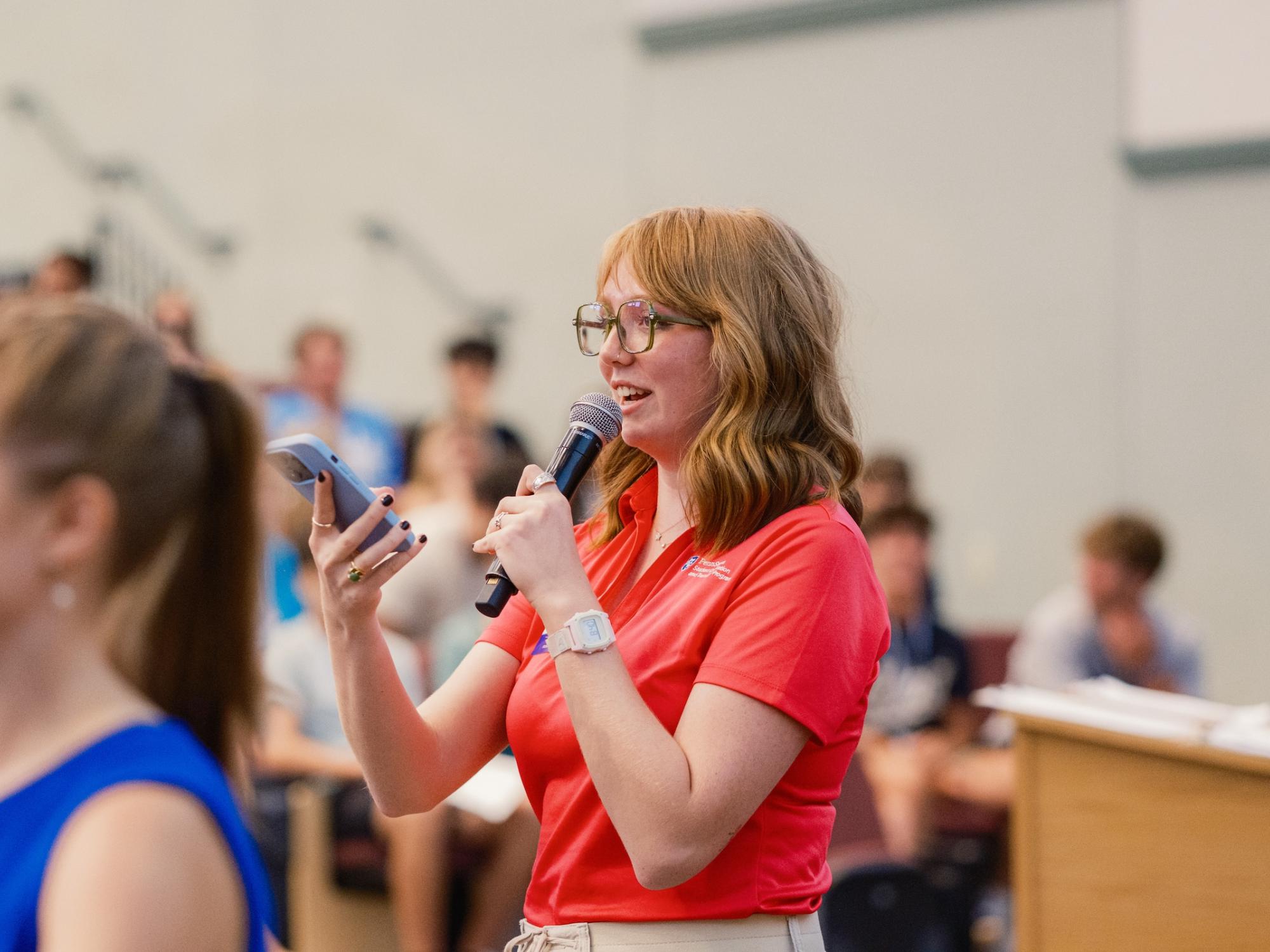 Orientation leader talking into microphone during NSO
