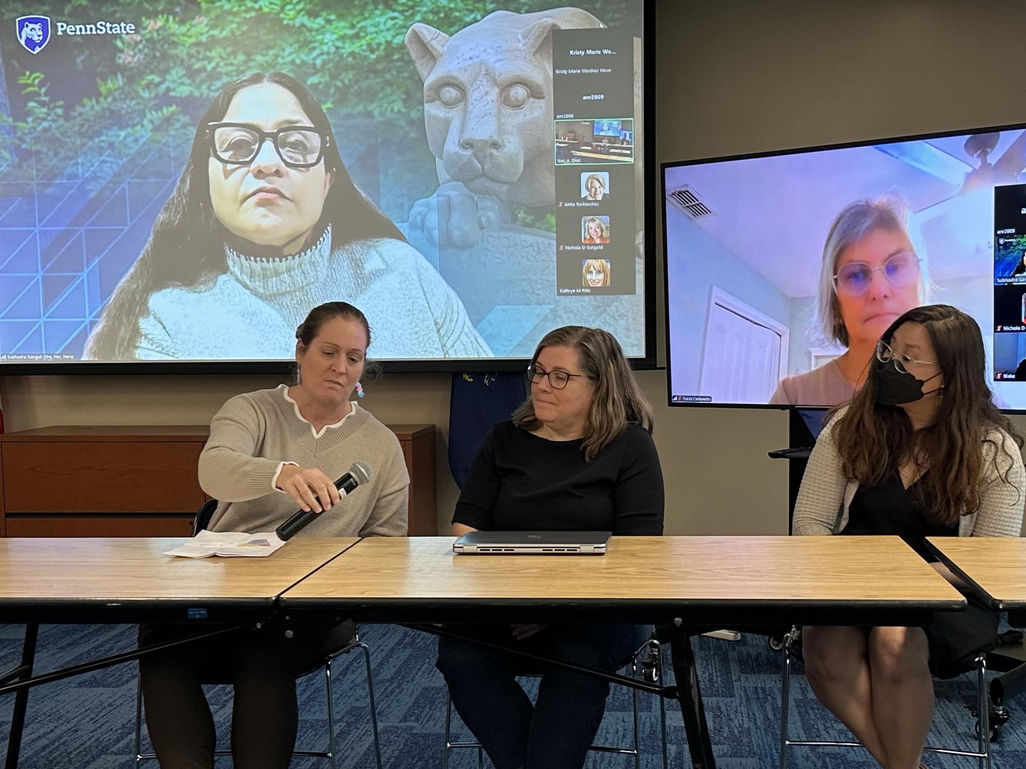 speakers sitting at a table during a panel discussion