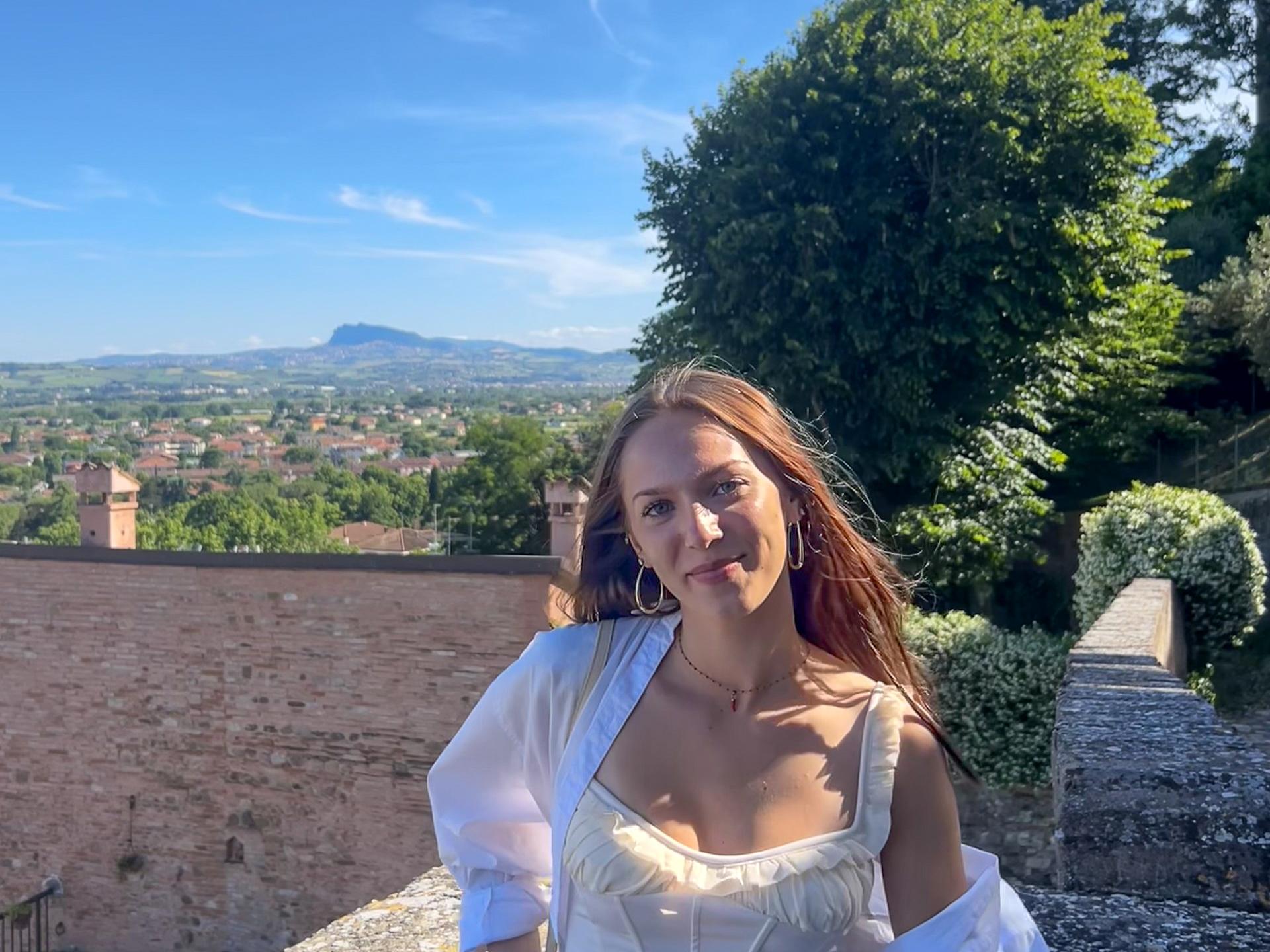Alexis Wilson stands with the countryside behind her in Rimini, Italy.