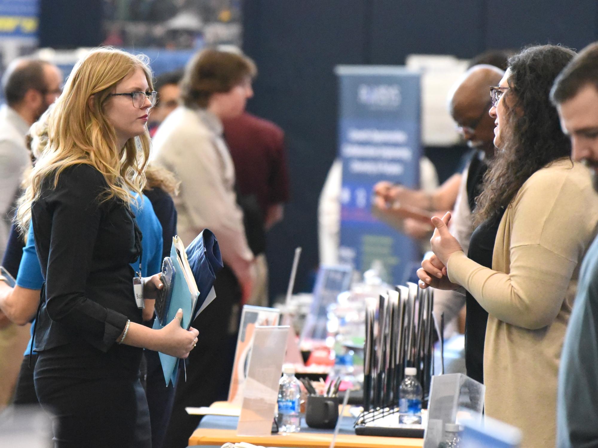 A female student talks with a recruiter at Penn State Behrend's career fair.