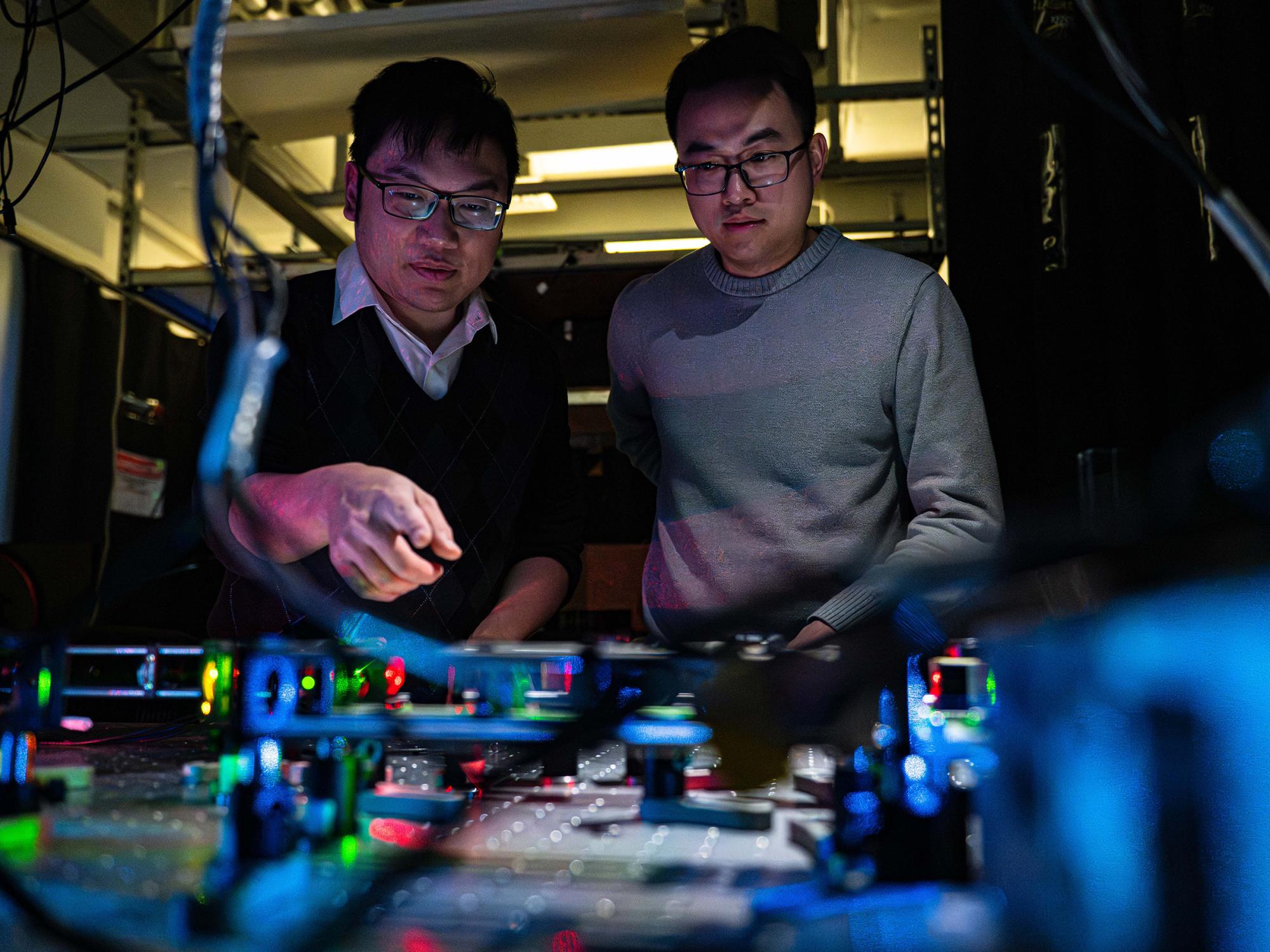 Two researchers in a lab using lasers for imaging