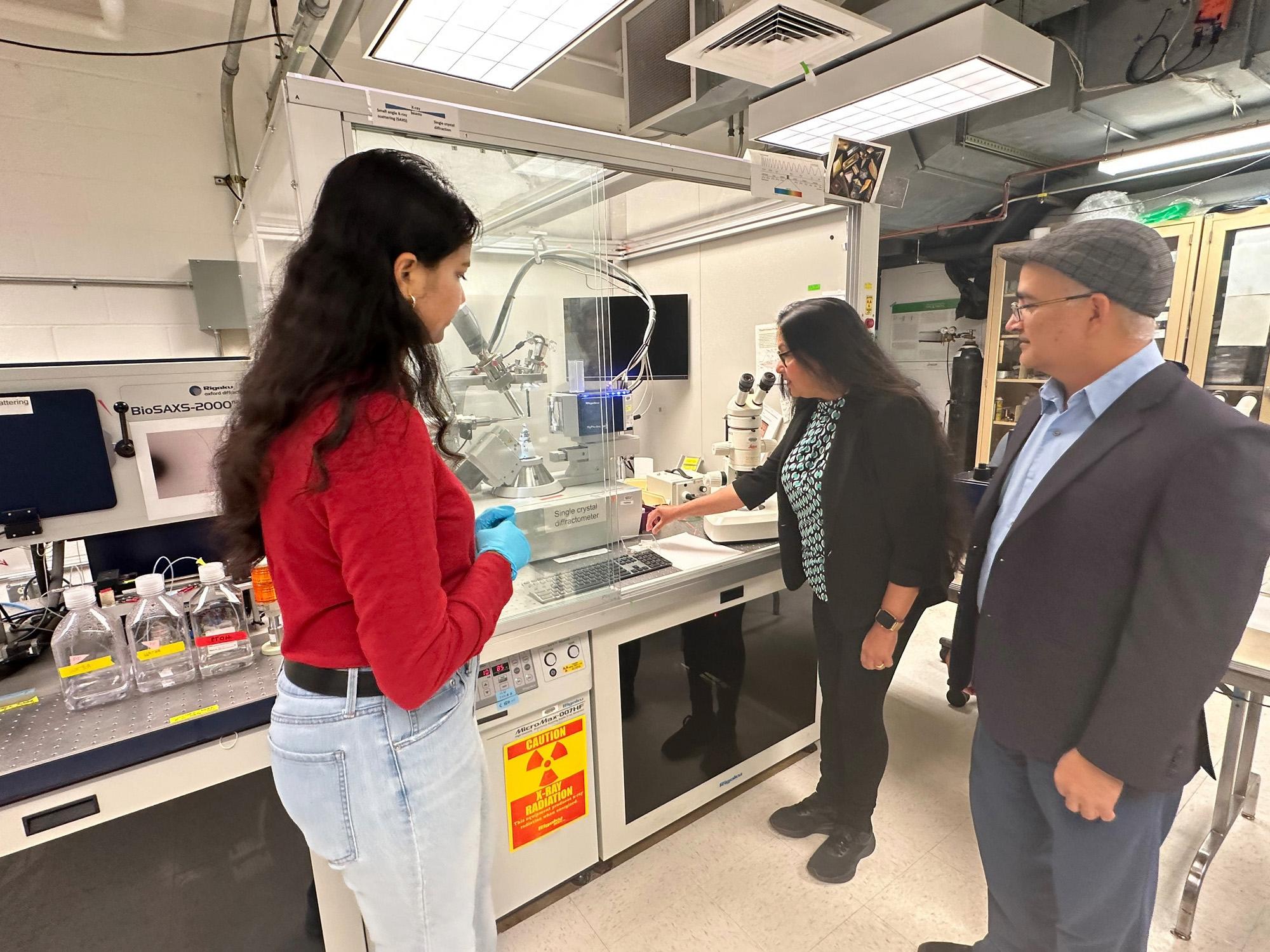 Three people stand in a lab