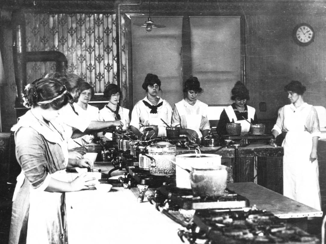 A black and white photo c. 1900 of women students in a cooking class