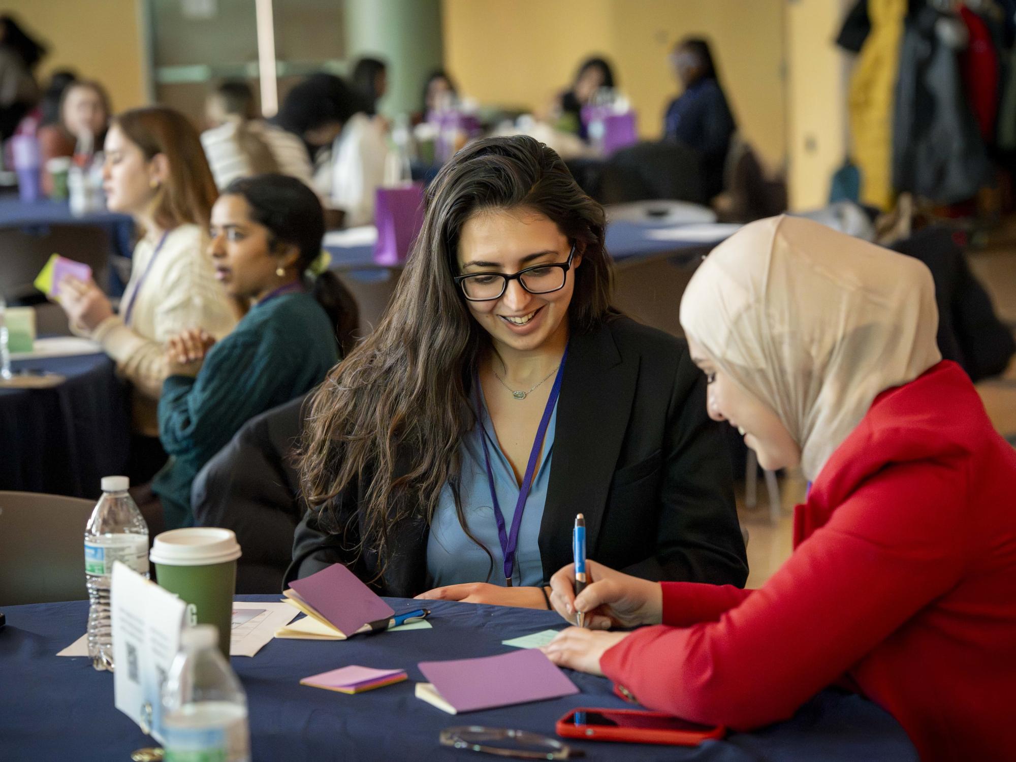 Two 2026 Empower Conference attendees working on an activity with post-it notes.
