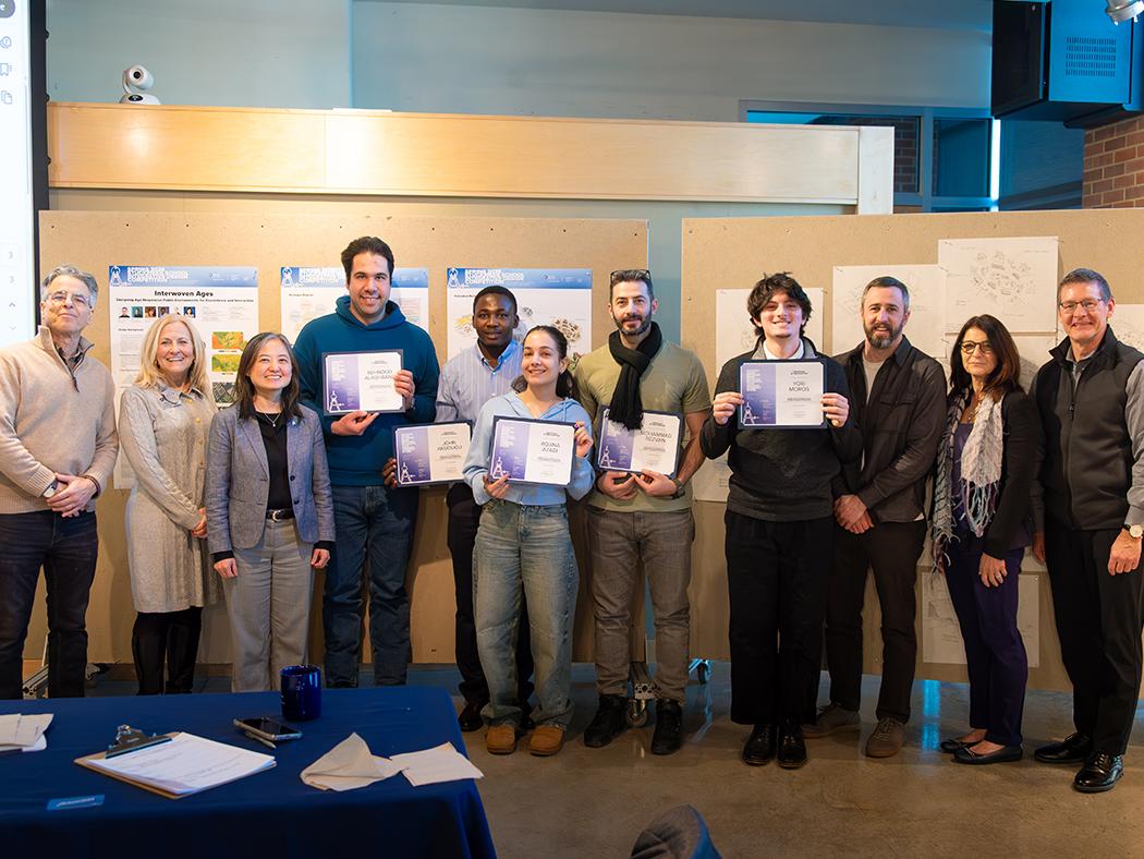 A group of people stands together in an indoor event space, posing for a photo. 