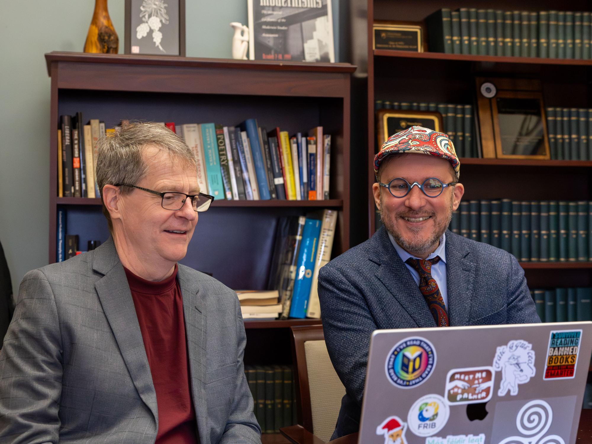 Liberal Arts faculty members Mark Morrisson on left and Tommaso M. Milani sit at a desk and look at a laptop computer screen