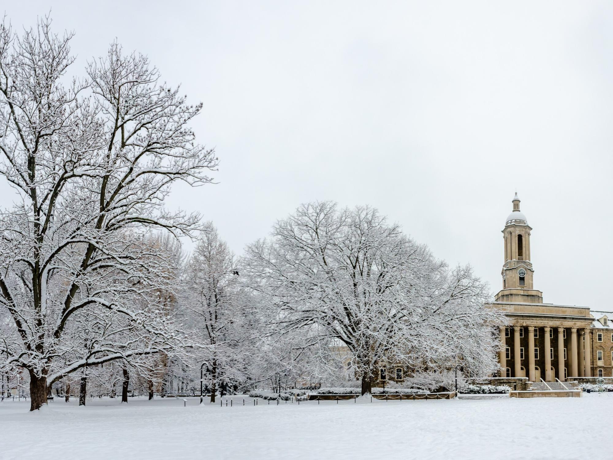 A wide shot of a snow covered Old Main lawn on Penn State's University Park campus