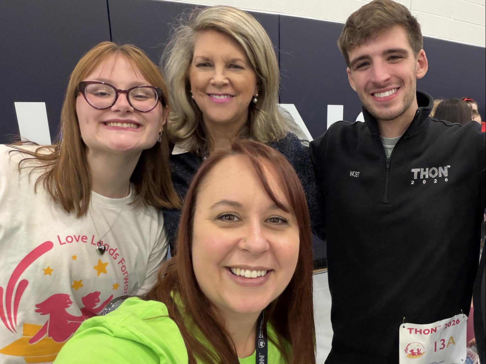 Four people pose for a selfie in a gym.
