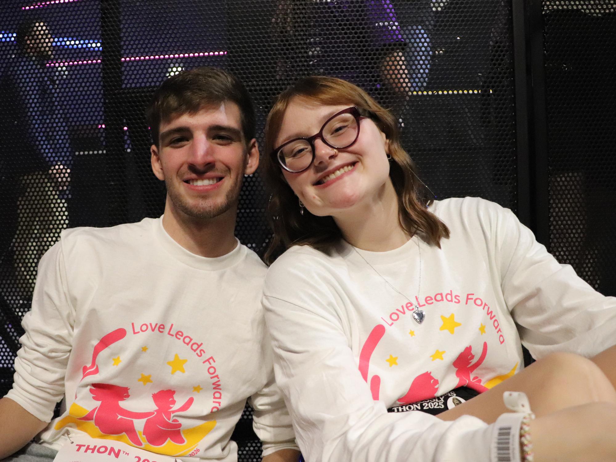 Two people wearing matching shirts pose for a photo.
