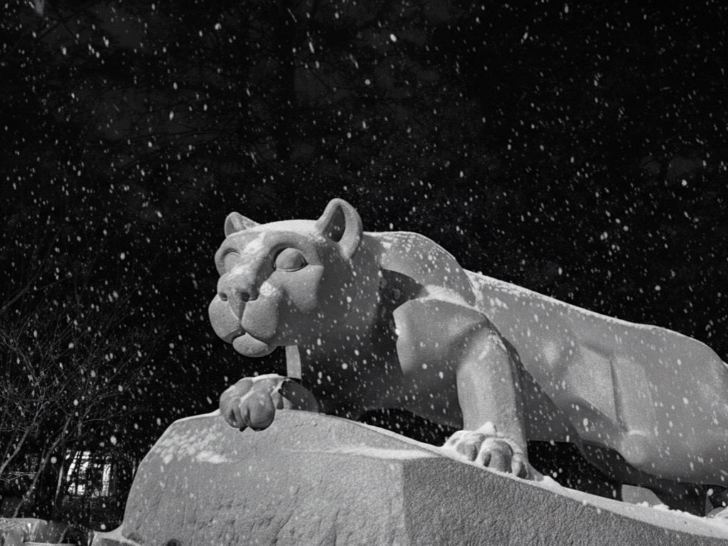 A black and white picture of the Nittany Lion Shrine during snowfall