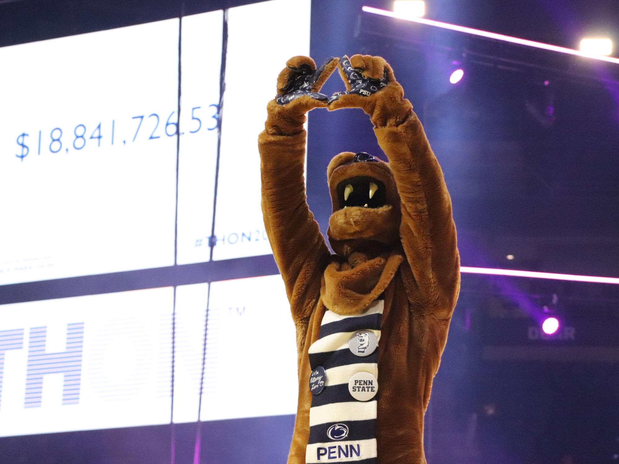 The Nittany Lion mascot makes a diamond with its paws in an arena.