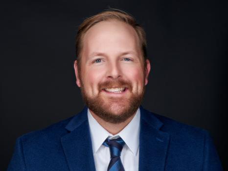 A photo of a smiling Curtis Fenton who is wearing a suit and tie