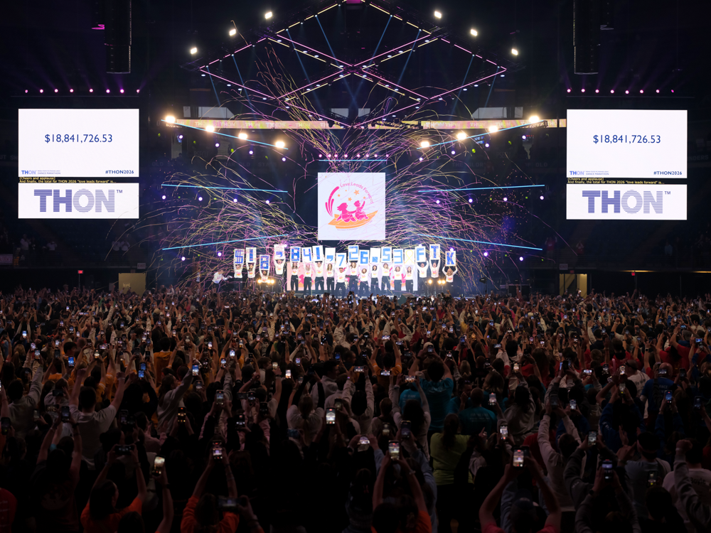 Large crowd facing the stage as people on stage hold up a number, $18,841,726.52