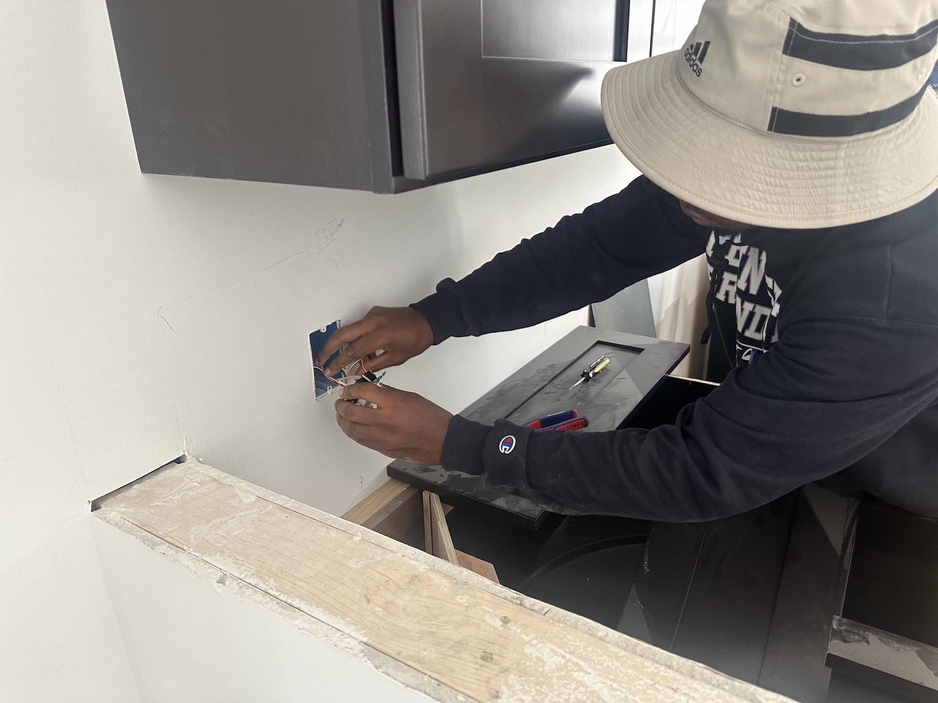 Student working with wires in a house