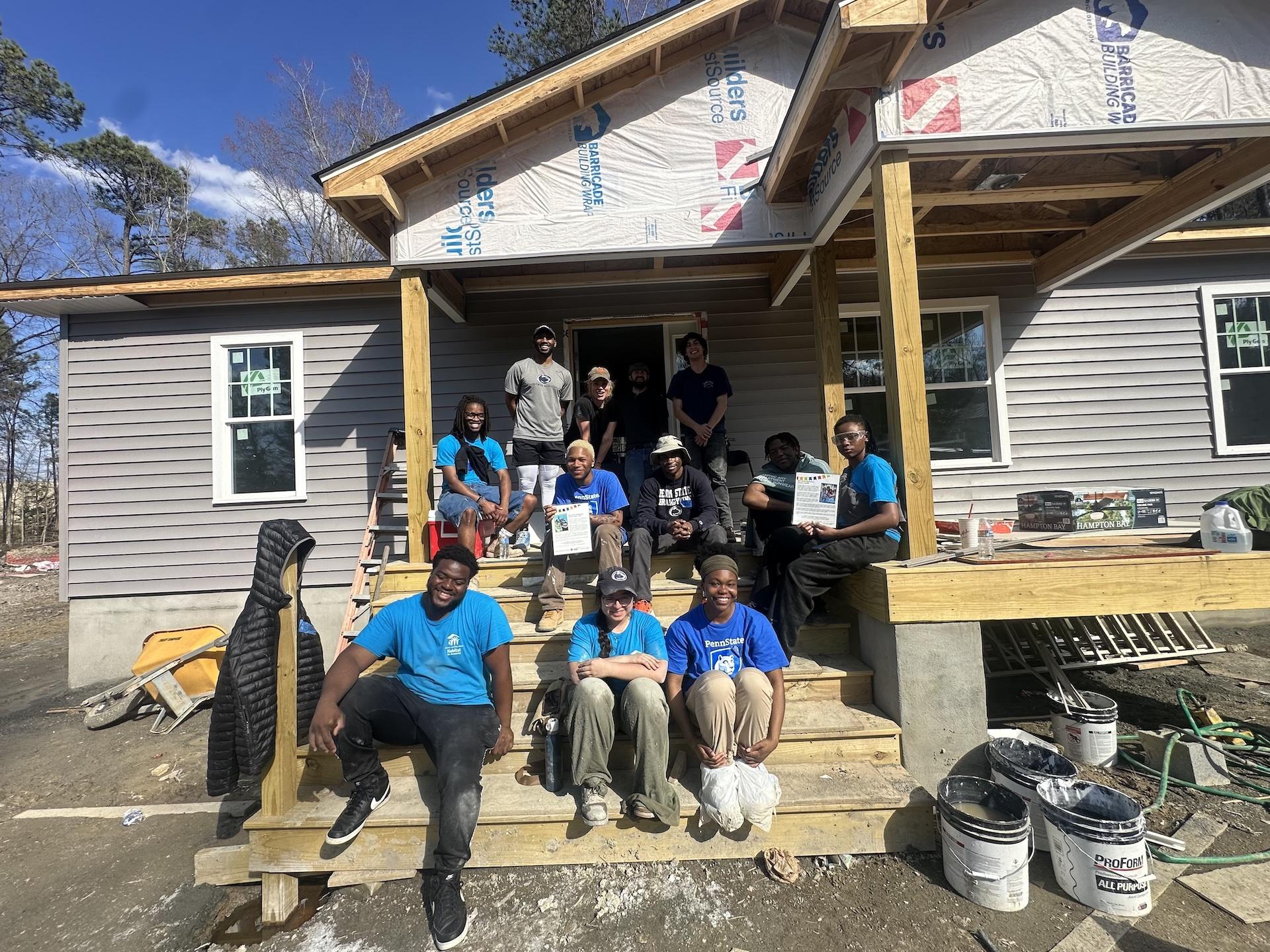students outside a house they nearly finished building in three days