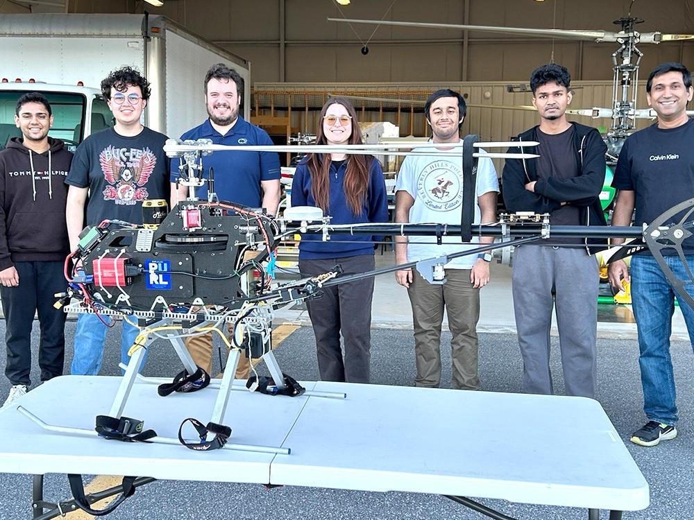 Seven people stand behind an unmanned emergency response vehicle prototype. 