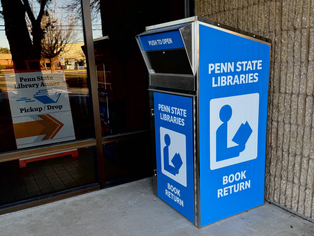 photo of large metal book return bin outside glass-fronted office building
