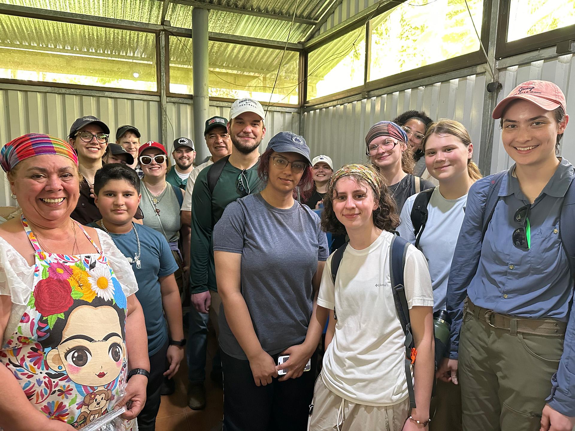 A Costa Rican farmer with U.S. college students in a coffee-processing facility