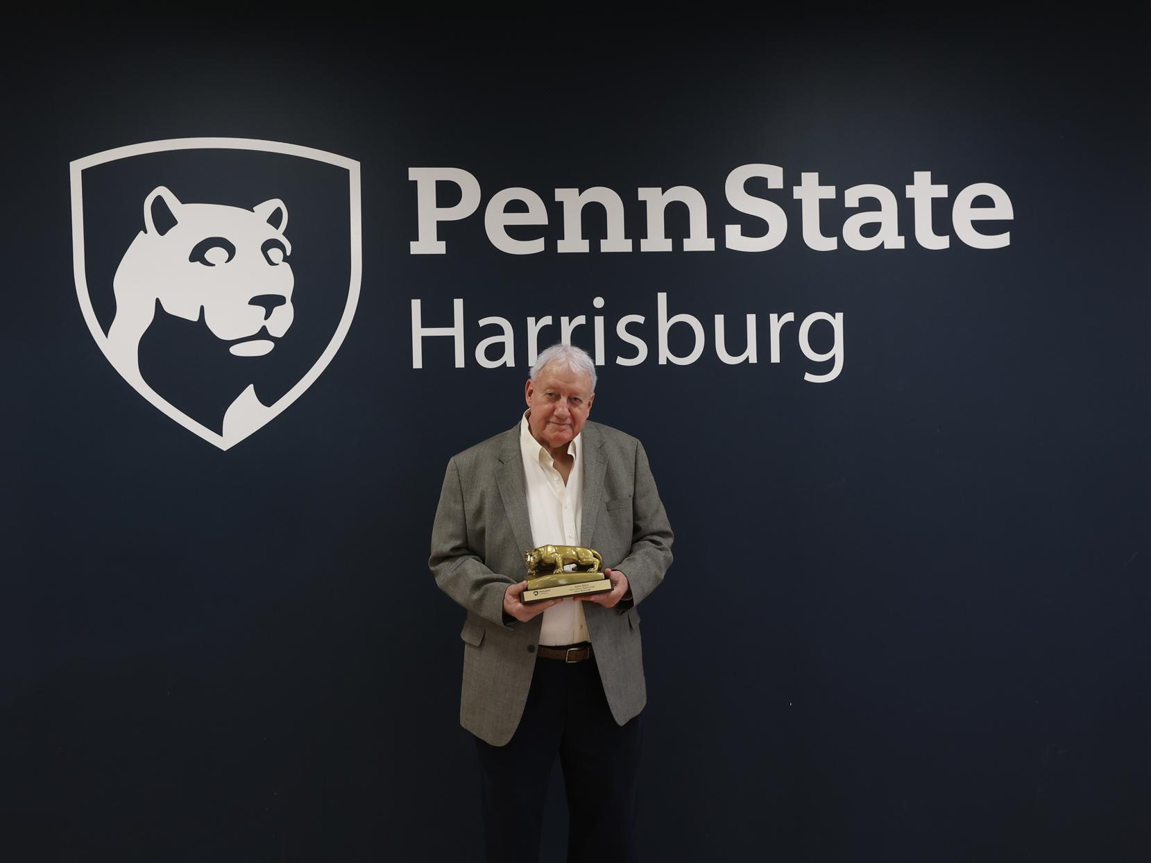 Jim Baker holds a statue awarded when he was inducted into the Penn State Harrisburg Athletics Hall of Fame