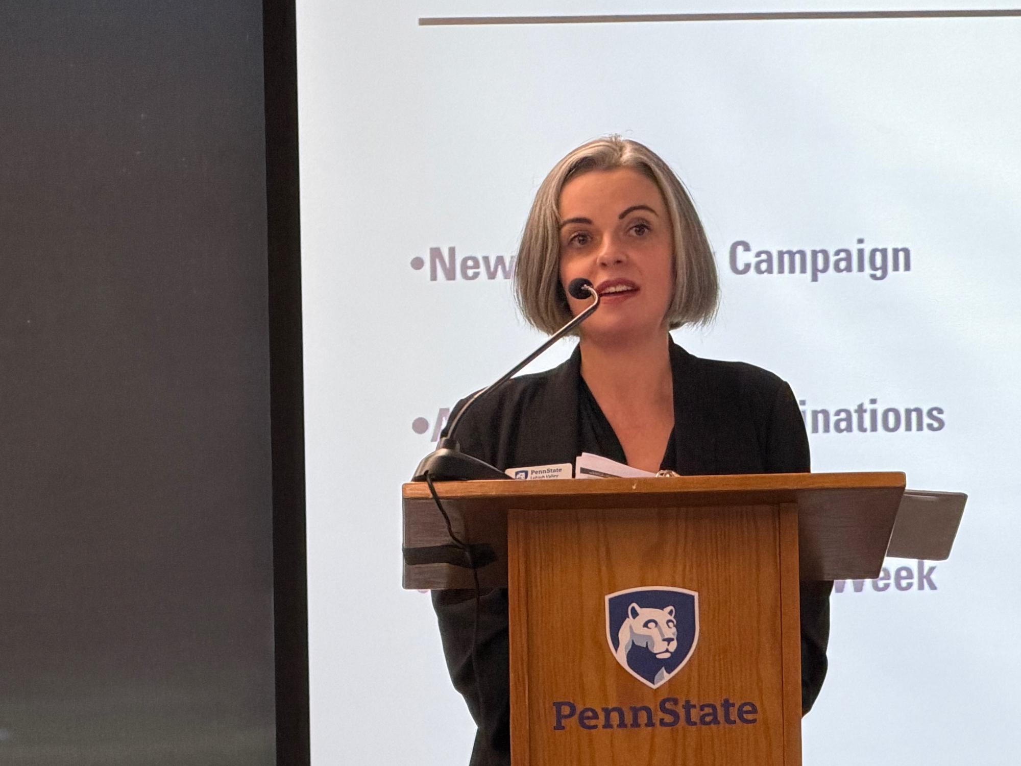 woman standing at a podium and speaking