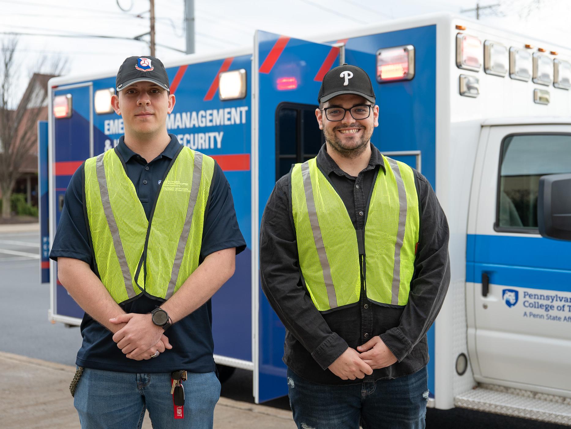 Two people with yellow vests stand together for a photo.