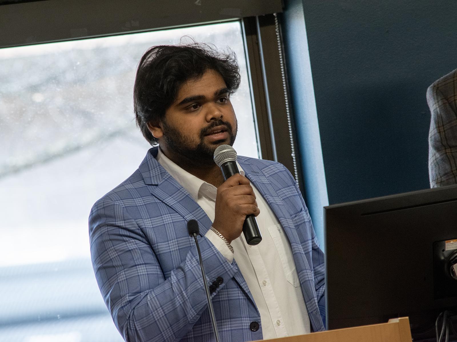 Likith Giddi speaks into a microphone