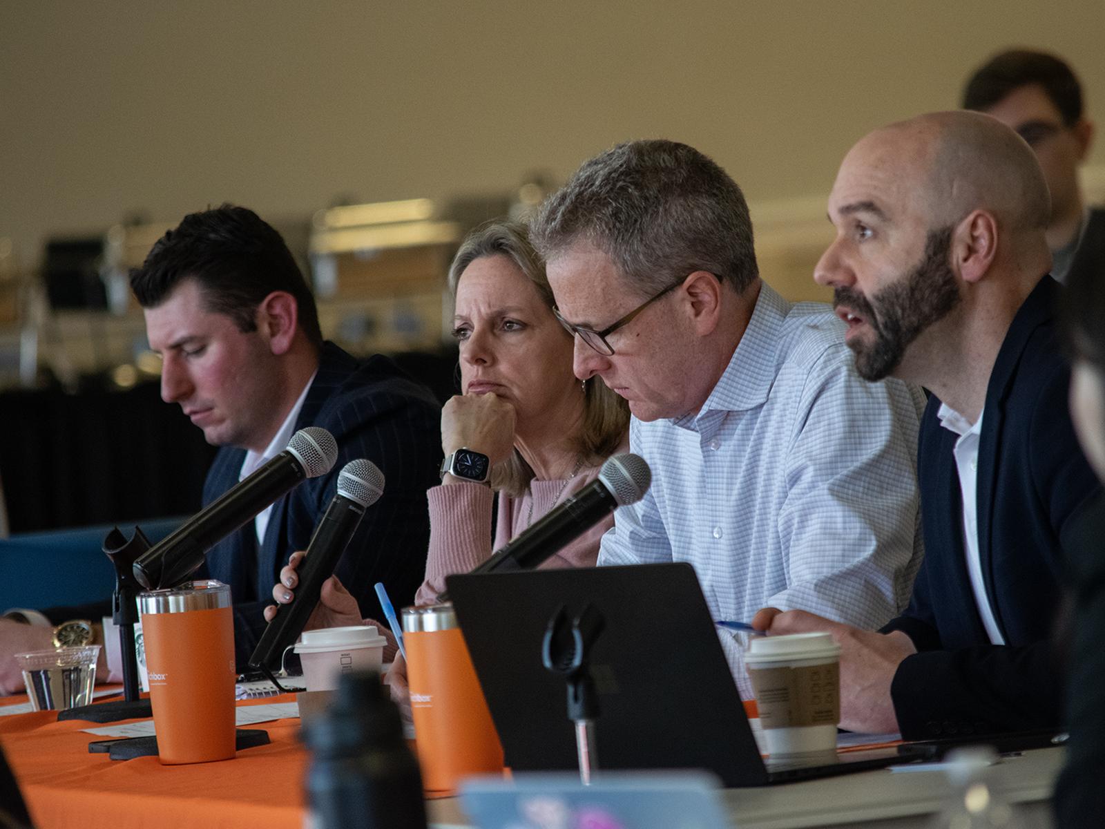 A panel of community business representatives listen to student pitches during a competition