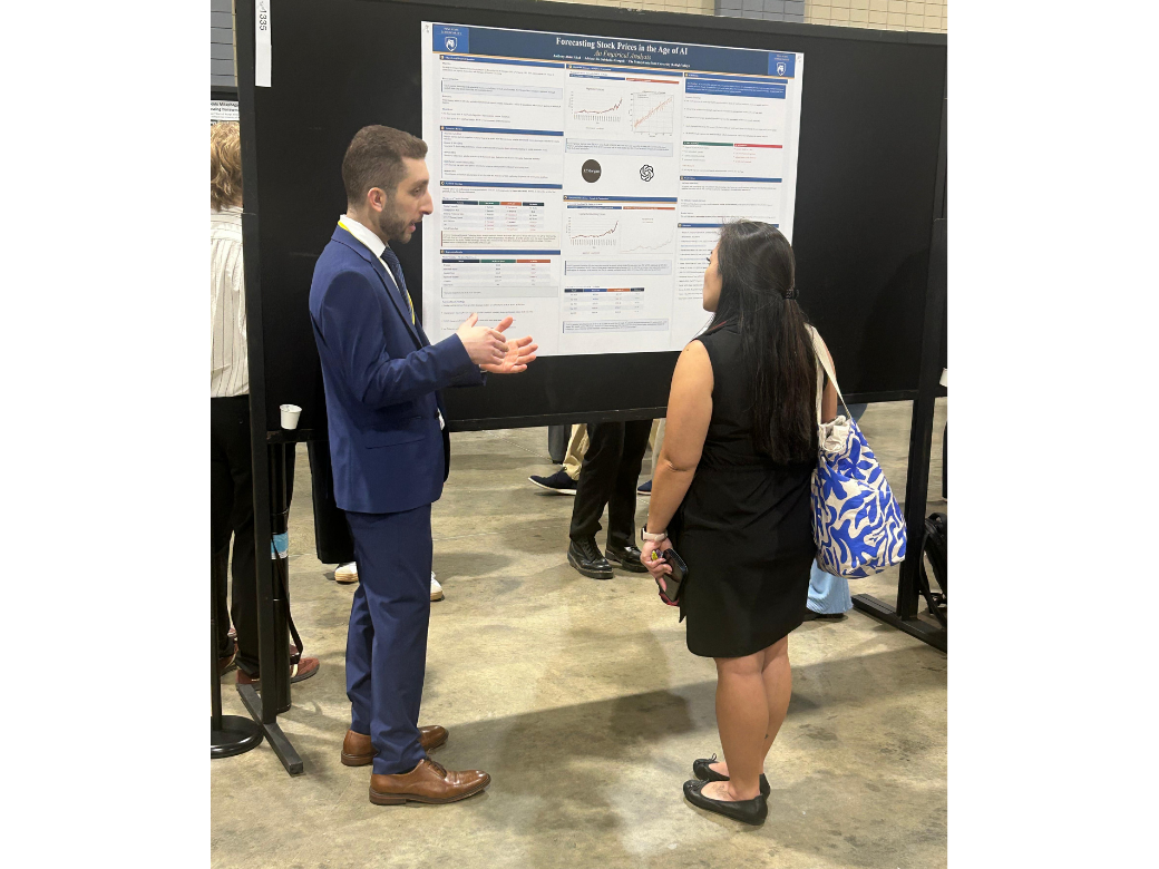 a male student explains his research to a female conference attendee.