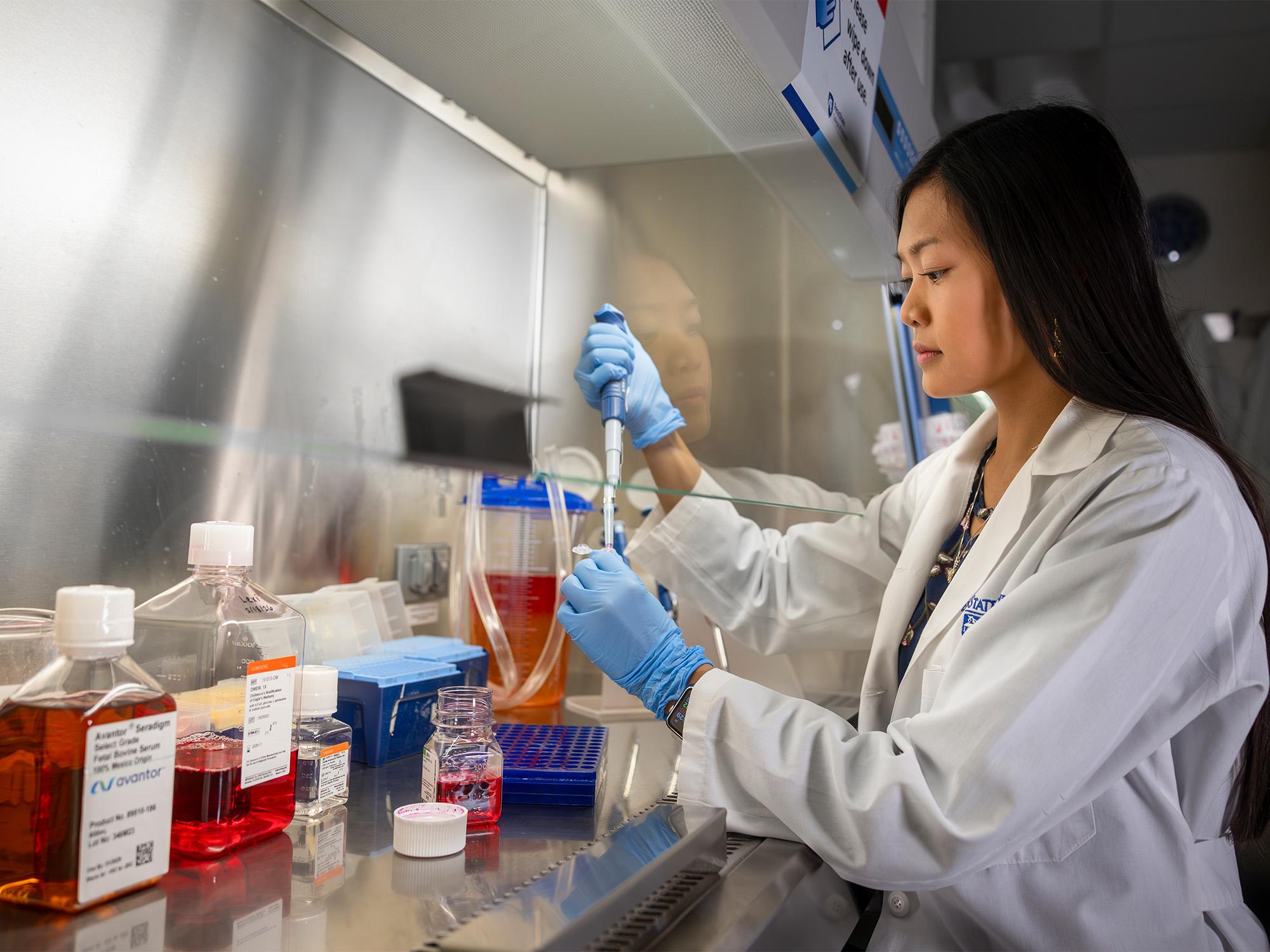 woman using pipet in lab