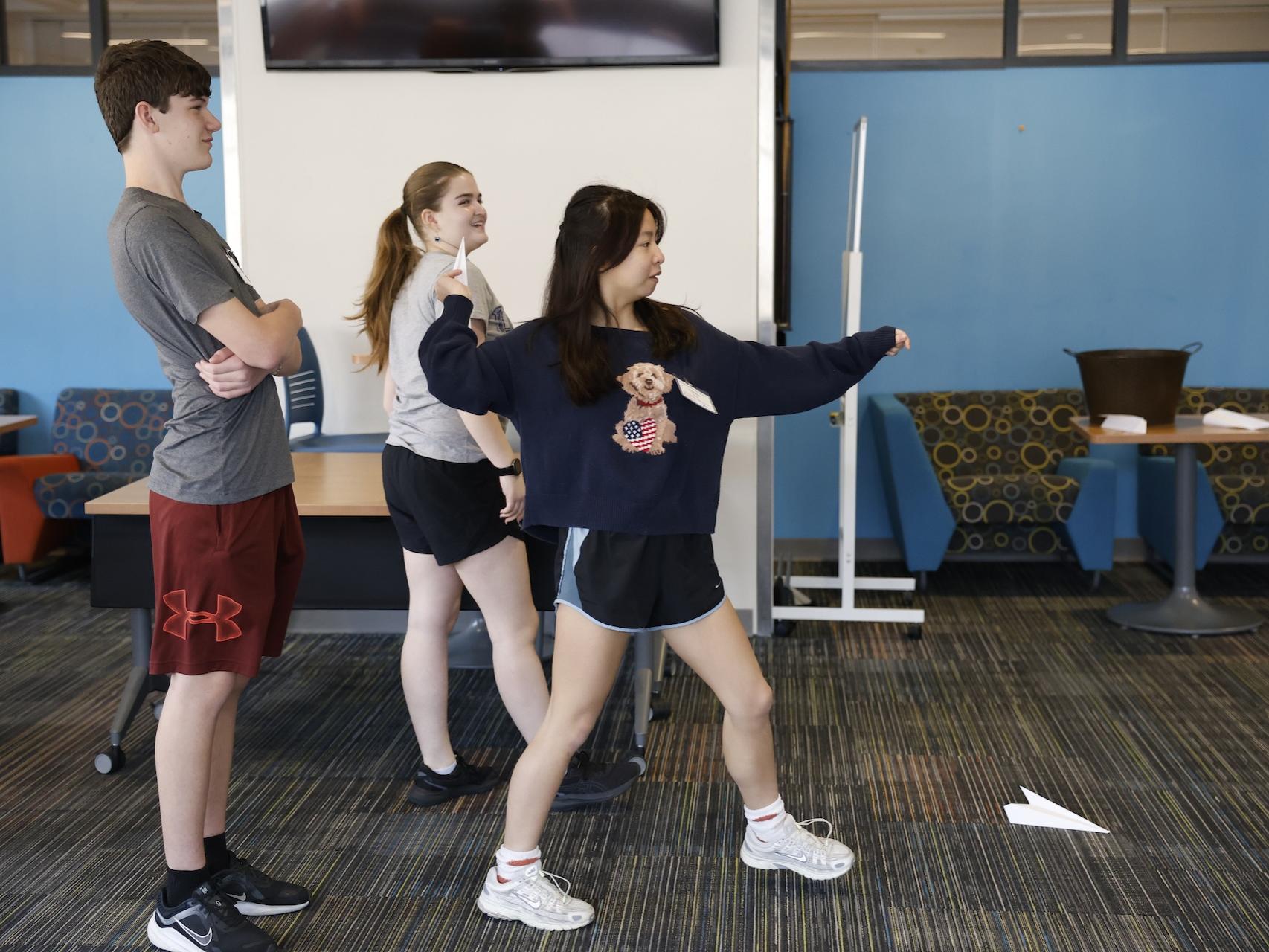 students throwing paper airplanes