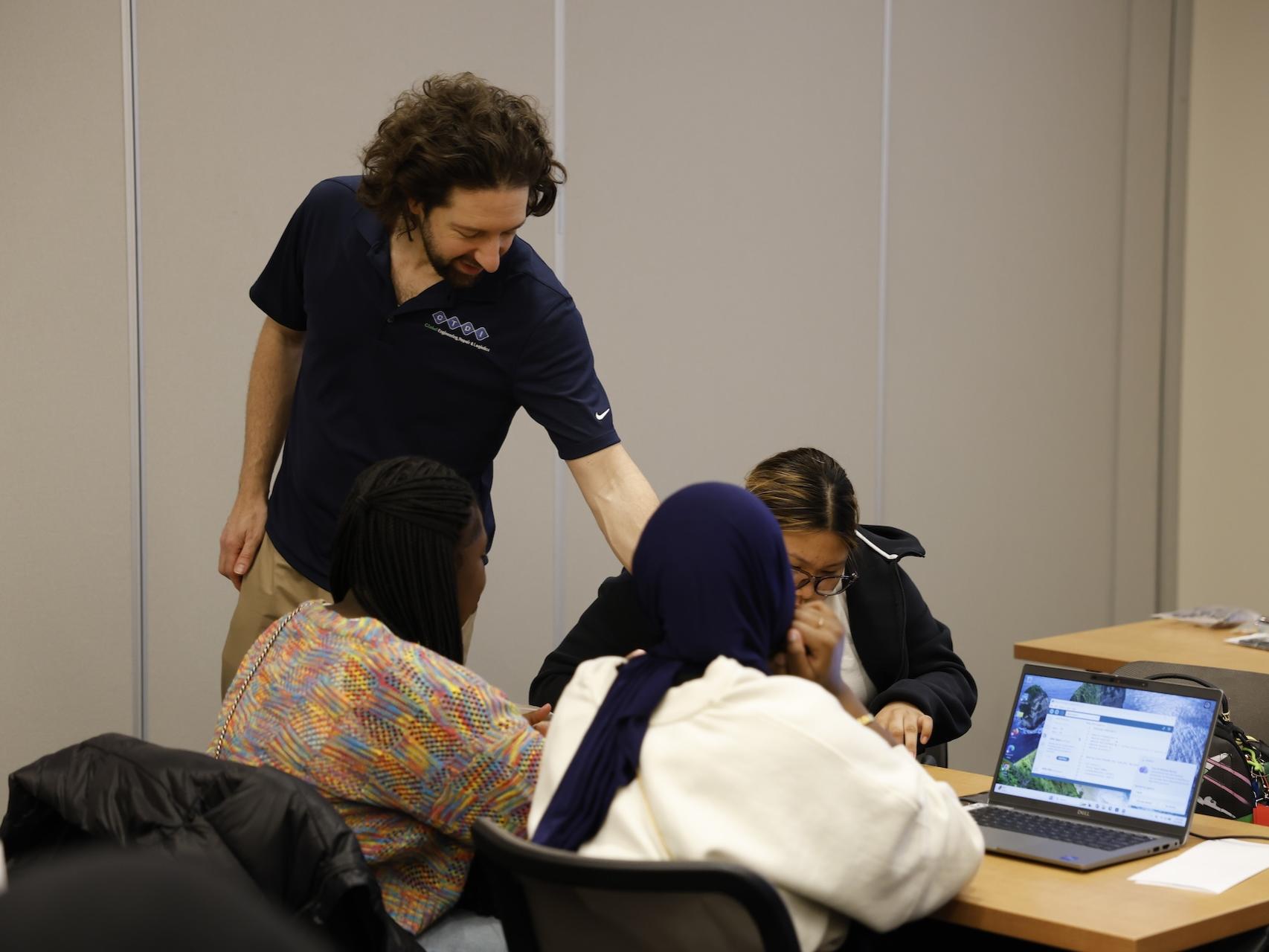 students with CTDI employee working on laptop