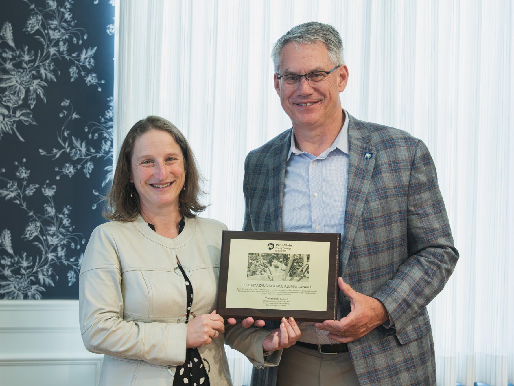 Christopher Cabell accepting the Outstanding Science Alumni Award from Penn State Eberly College of Science Dean Tracy Langkilde.
